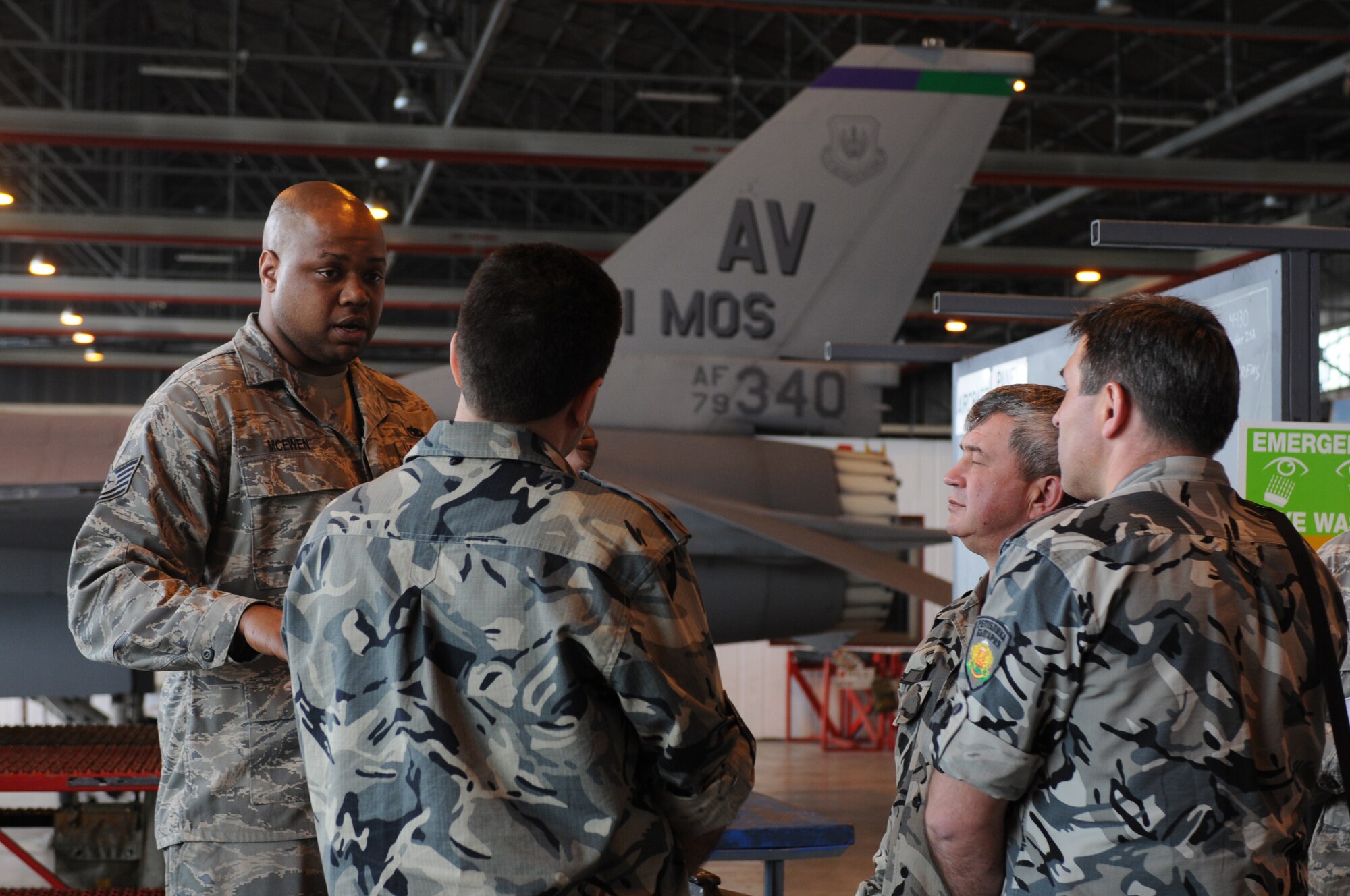 Tech. Sgt. Jonathan McEwen, 31st Maintenance Squadron phase section dock chief, briefs members of the Bulgarian air force on the purpose of having aircraft come into phase for yearly overhauls April 14. The main focus of the visit was to educate the Bulgarian and Romanian air forces on how Team Aviano trains and develops maintenance Airmen from the lowest rank to senior noncommissioned officer level.  (U.S. Air Force photo/ Staff Sgt. Nadine Y. Barclay)