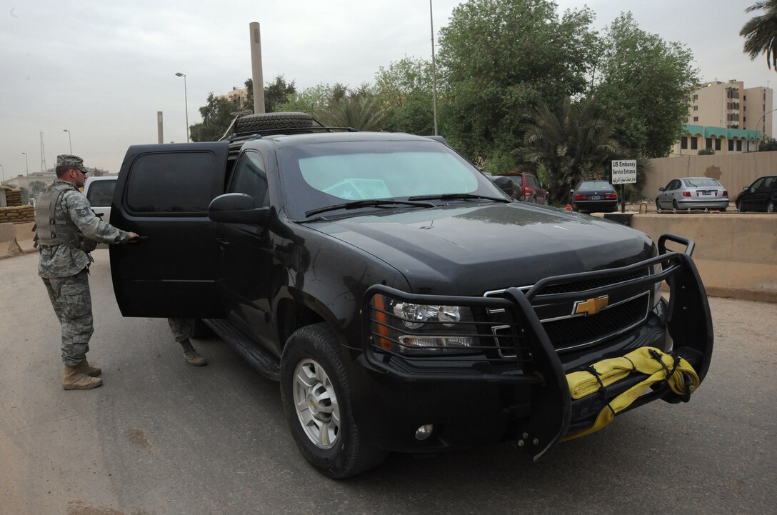 Air Force Tech. Sgt. Matt Loiselle, Personal Security Advisor for the Air Component Coordination Element Director, checks to ensure the surrounding area is secure before the general is removed from the vehicle inside the U.S. Embassy compound, Baghdad, Iraq, March 24, 2010. Sergeant Loiselle has been in charge of three teams consisting of 40 Army personnel, who were deployed from locations such as the Kentucky and Tennessee Army National Guard units and he trained them to be part of this team.  (U.S. Air Force photo/Master Sgt. Trish Bunting/Released)