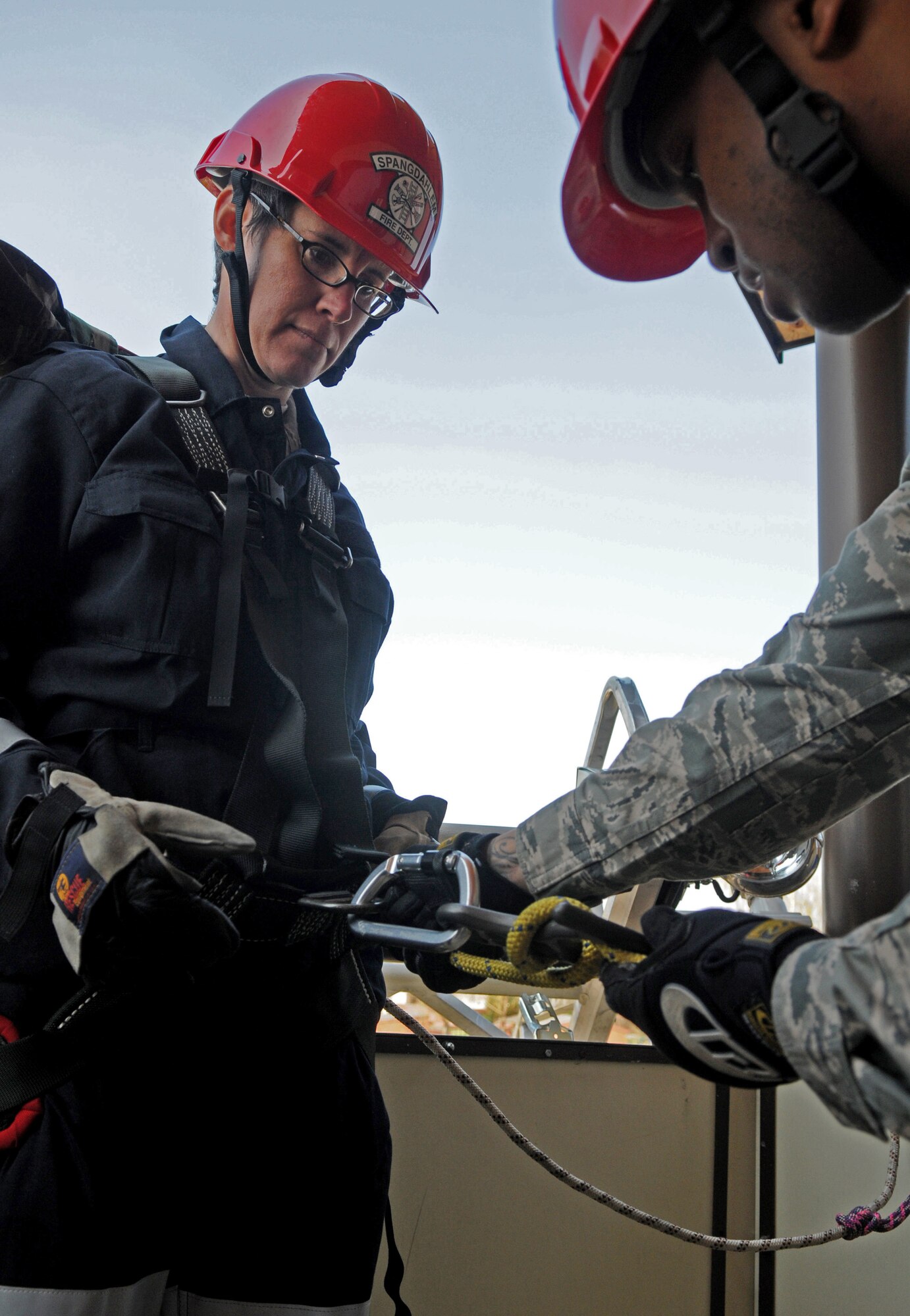 SPANGDAHLEM AIR BASE, Germany – Tech. Sgt. Shanton Russel, right, 52nd Civil Engineer Squadron firefighter, attaches a tactical harness to Col. Jodine Tooke, 52nd Mission Support Group commander, April 16. The 52nd CES firefighters led Colonel Tooke through numerous firefighting exercises to provide first-hand experience. (U.S. Air Force photo/Airman 1st Class Staci Miller)