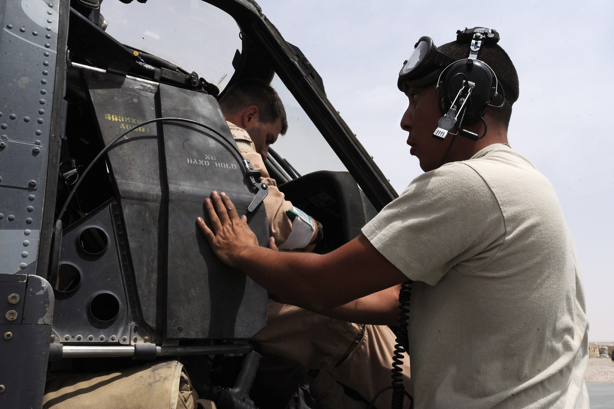 Senior Airman Robert Fabela, an HH-60G Pave Hawk crew chief assigned to the 451st Expeditionary Aircraft Maintenance Squadron helicopter maintenance unit, seals an HH-60G helicopter cockpit prior to take-off April, 16, 2010, at Camp Bastion, Afghanistan. (U.S. Air Force photo/Staff Sgt. Manuel J. Martinez/released)

