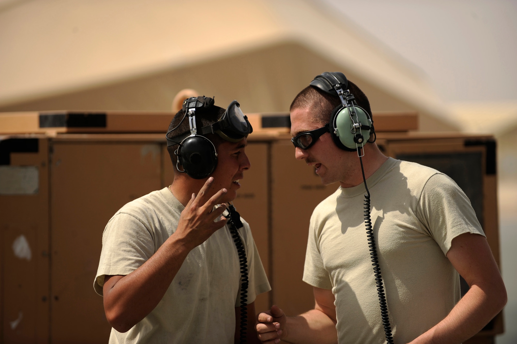 Senior Airman Robert Fabela, left, an HH-60G Pave Hawk crew chief and Staff Sgt. Roger Anderson, an HH-60G Pave Hawk communications and navigations equipment specialist both assigned to the 451st Expeditionary Aircraft Maintenance Squadron helicopter maintenance unit, converse while waiting for an HH-60G helicopter aircrew to stop the engine after returning from an alert mission, April, 16, 2010, at Camp Bastion, Afghanistan. (U.S. Air Force photo/Staff Sgt. Manuel J. Martinez/released)
