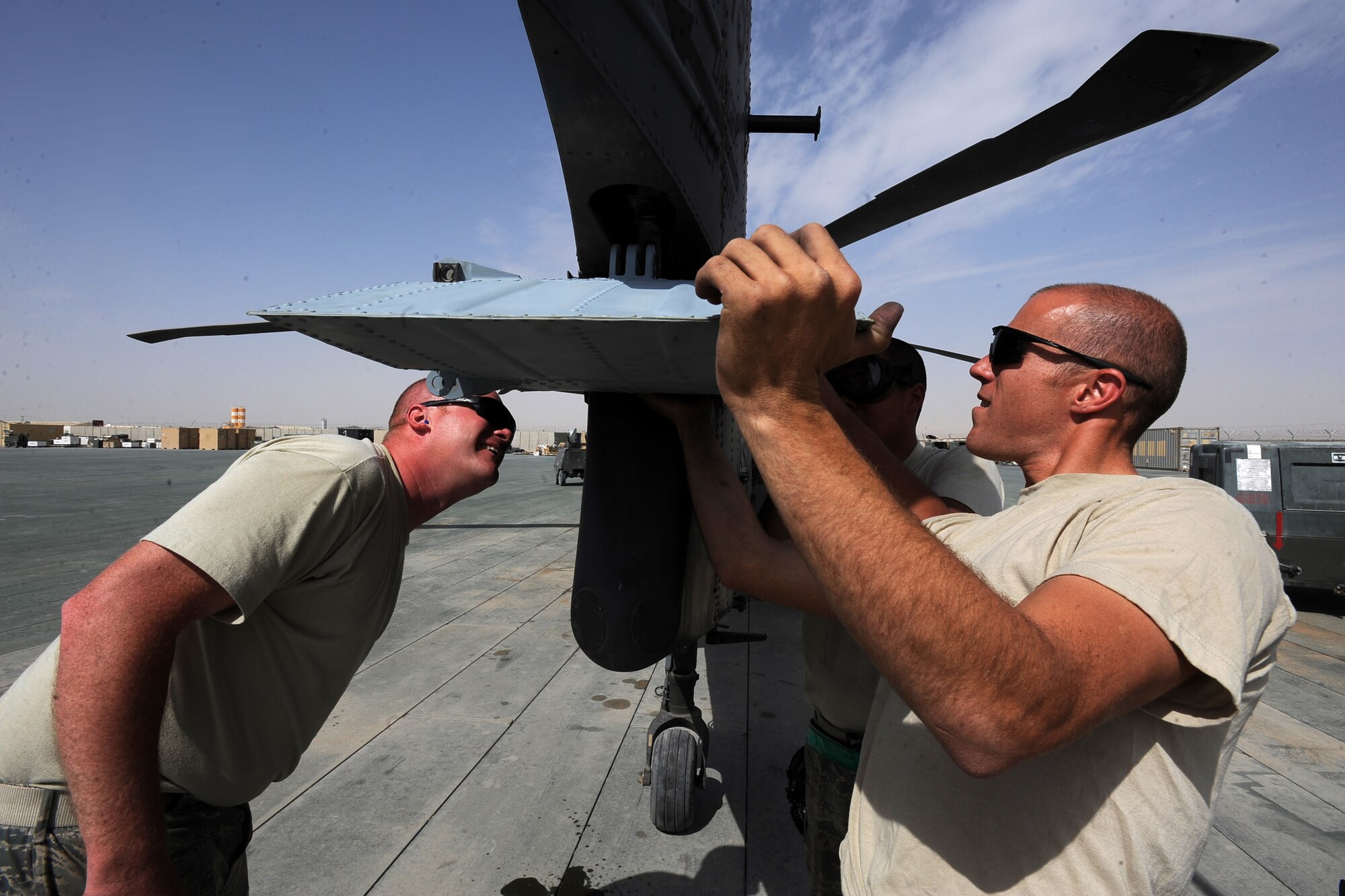 Left to right, Staff Sgts. Greg Enberlin, Ryan Click and Senior Airman Robert Fabela, HH-60G Pave Hawk crew chiefs assigned to the 451st Expeditionary Aircraft Maintenance Squadron helicopter maintenance unit,  install a stabalator on a back-up HH-60G helicopter April, 16, 2010, at Camp Bastion, Afghanistan. The maintenance Airmen, who have witnessed as many as 26 sorties here in one day, spend an average of 168 man-hours a week to ensure rescue aircrews are ready to fly when called. (U.S. Air Force photo/Staff Sgt. Manuel J. Martinez/released)