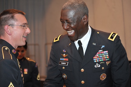 Maj. Gen. Abraham J. Turner, chief of staff, U.S. Strategic Command, laughs with fellow tuba player Master Sgt. Scott Cameron, the U.S. Army Field Band and Soldiers&#039; Chorus at the Boys Town Music Hall in Omaha, Neb. April 20.  During the concert, General Turner joined the tuba section during the musical selection &quot;The Chesapeake Bay March.&quot;