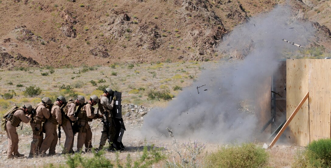 Members of the Marine Wing Support Squadron 373 explosive ordnance disposal team brace themselves from the blast of a breaching charge behind a blast blanket during training at Camp Billy Machen in California, April 20, 2010. The team trained with breaching charges for an upcoming deployment to Afghanistan. The team stayed in Yuma due to the air station’s proximity to the ranges and to train with MWSS-371 and station EOD teams.