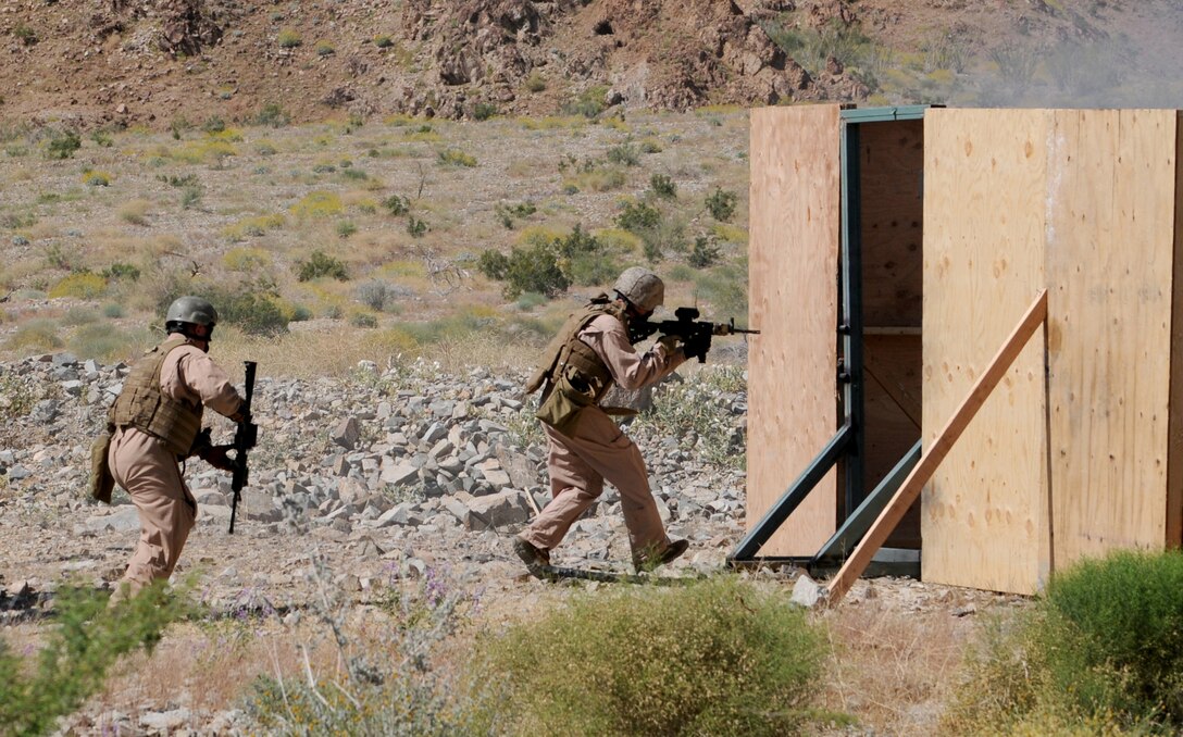 Members of the Marine Wing Support Squadron 373 explosive ordnance disposal team rush into a structure they built for training purposes. The team trained with breaching charges for an upcoming deployment to Afghanistan. The team stayed in Yuma due to the air station’s proximity to the ranges and to train with MWSS-371 and station EOD teams. Master Gunnery Sgt. Carl Holden, MWSS-371 EOD staff noncommissioned officer in charge and a former close-quarters battle instructor for Marine Special Operations Command, taught the Marines the advanced rifle and pistol techniques he used to teach to force reconnaissance Marines.