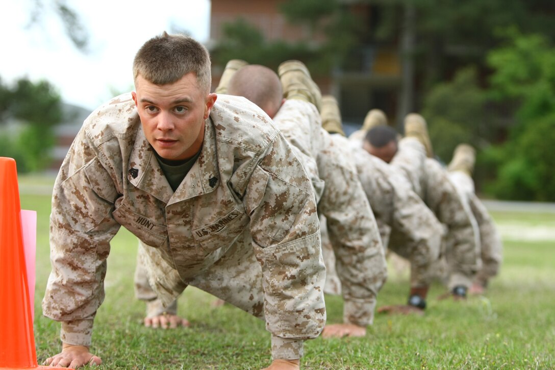 Sgt. Robert Hunt, a combat instructor with Company I, Marine Combat Training Battalion, School of Infantry-East, leads his team in squad push-ups during the initial stage of the MCT Battalion Combat Instructor Competition aboard Camp Geiger, N.C., April 21.  Squad push-ups were just one of many exercises that tested the physical and mental strength of 25 MCT instructors who competed in the two-day event.