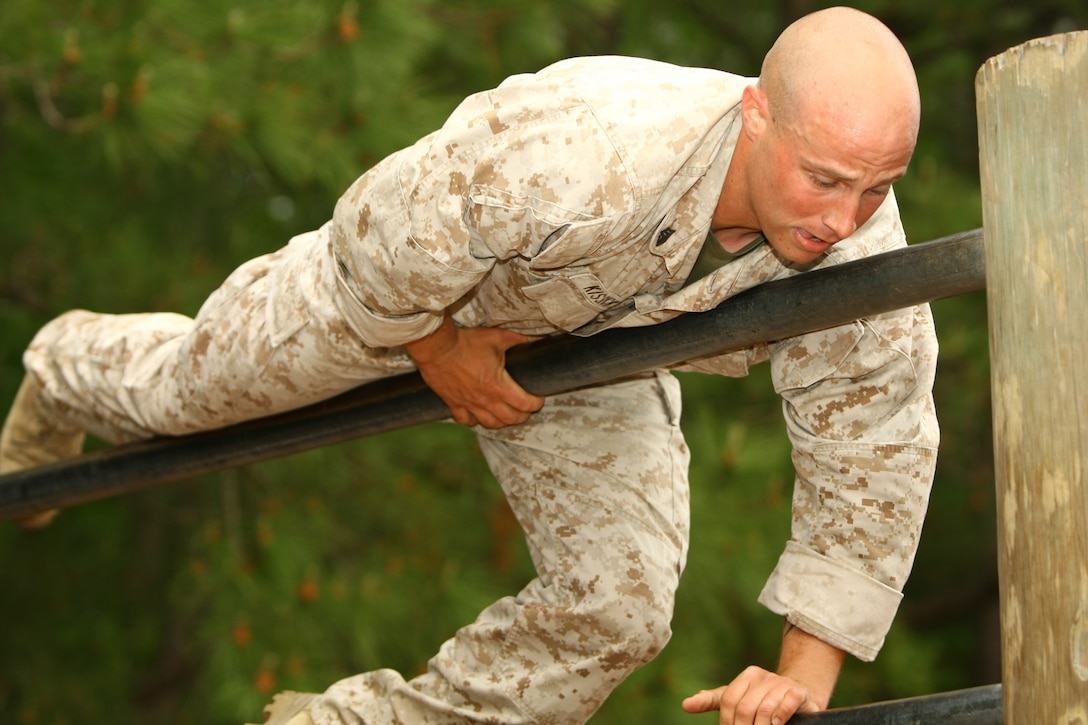 Sgt. Andrew Kissick, a combat instructor with Company G, Marine Combat Training Battalion, School of Infantry-East, climbs over the double bars during the obstacle course portion of the MCT Battalion Combat Instructor Competition aboard Camp Geiger, N.C., April 21.  Kissick and 24 other combat instructors ran the O-course right after finishing a one-mile stretcher run and right before a three-mile hike with heavy equipment to Camp Devil Dog.