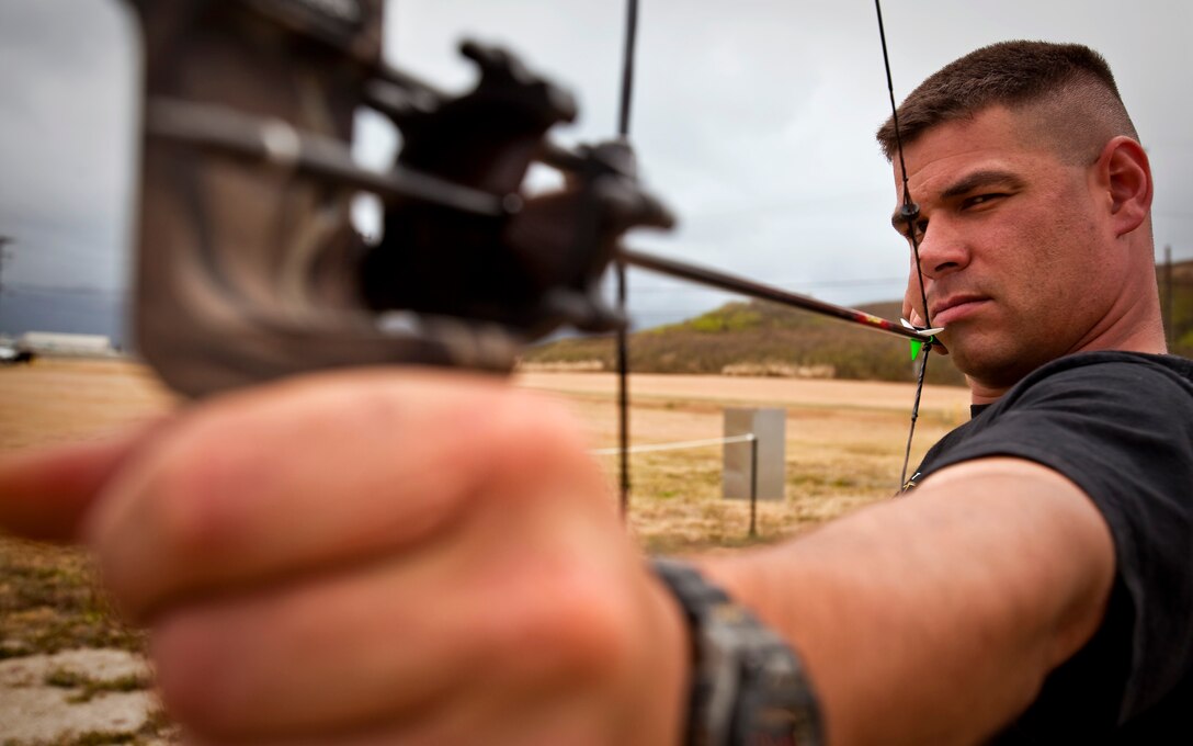 Cpl. Beau Parra, machine gunner, Wounded Warrior Battalion, Detachment West, sights in on a practice target using a compound bow at MCB Hawaii's archery range, April 21. Parra competes in the archery and air pistol events during the first Wounded Warrior Games beginning May 10, in Colorado.