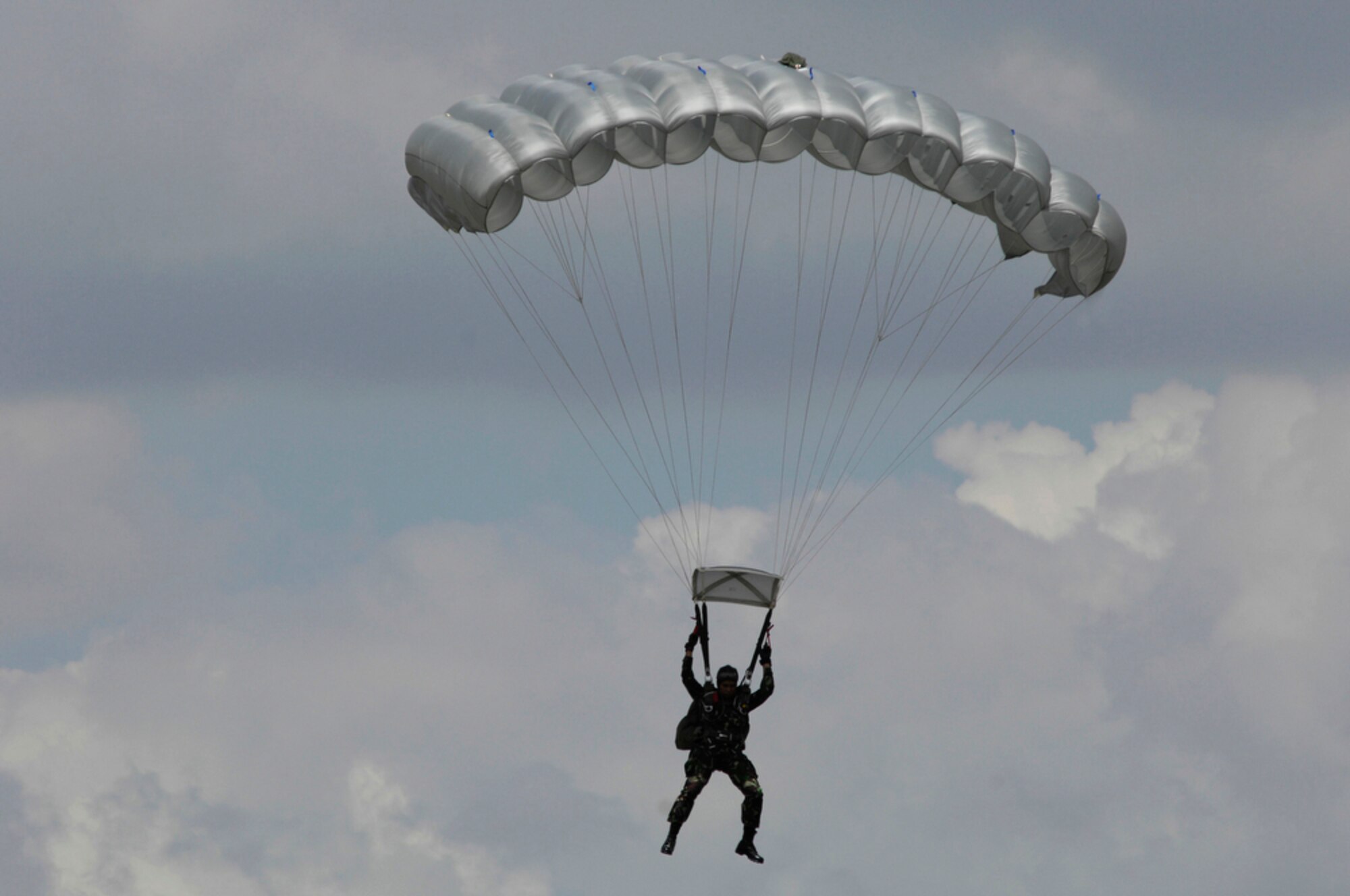 An Indonesian soldier glides to the ground after jumping from a C-130 Hercules April 21, 2010, during Cope West 10 at Halim Air Base, Indonesia.  Cope West is a Pacific Air Forces-sponsored bilateral tactical airlift exercise involving the U.S. and Indonesian air forces. The exercise is designed to advance interoperability between the two services, and promote cooperation and unity of purpose. (U.S. Air Force photo/Tech Sgt. Cohen A. Young)