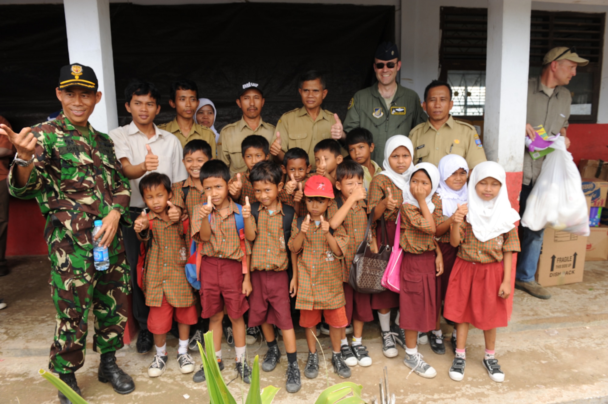 Lt. Col. Dave Kincaid joins the local Indonesian Air Force base commander and children from the Sd Negeri Gembor 2 Elementary School in Lanud Gorda Binuang, Indonesia, in giving a thumbs-up during a visit by U.S. Airmen to the school on April 21, 2010.  Colonel Kincaid, 36th Airlift Squadron commander, and other Airmen from Yokota AB are participating in Cope West 10, a Pacific Air Forces-sponsored bilateral tactical airlift exercise involving the U.S. and Indonesian air forces. The exercise is designed to advance interoperability between the two services, and promote cooperation and unity of purpose. (U.S. Air Force photo/Tech Sgt. Cohen A. Young)