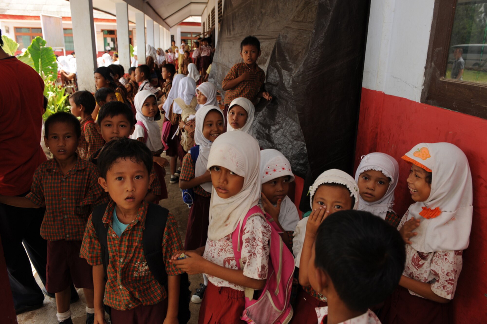 Indonesian children from the Sd Negeri Gembor 2 Elementary School in Lanud Gorda Binuang, Indonesia, greet Airmen from Yokota Air Base, Japan, as they arrive to donate more than 1,200 pounds of clothes, toys and sports equipment on April 21, 2010. The Yokota Airmen are participating in Cope West 10, a Pacific Air Forces-sponsored bilateral tactical airlift exercise involving the U.S. and Indonesian air forces. The exercise is designed to advance interoperability between the two services, and promote cooperation and unity of purpose. (U.S. Air Force photo/Tech Sgt. Cohen A. Young)