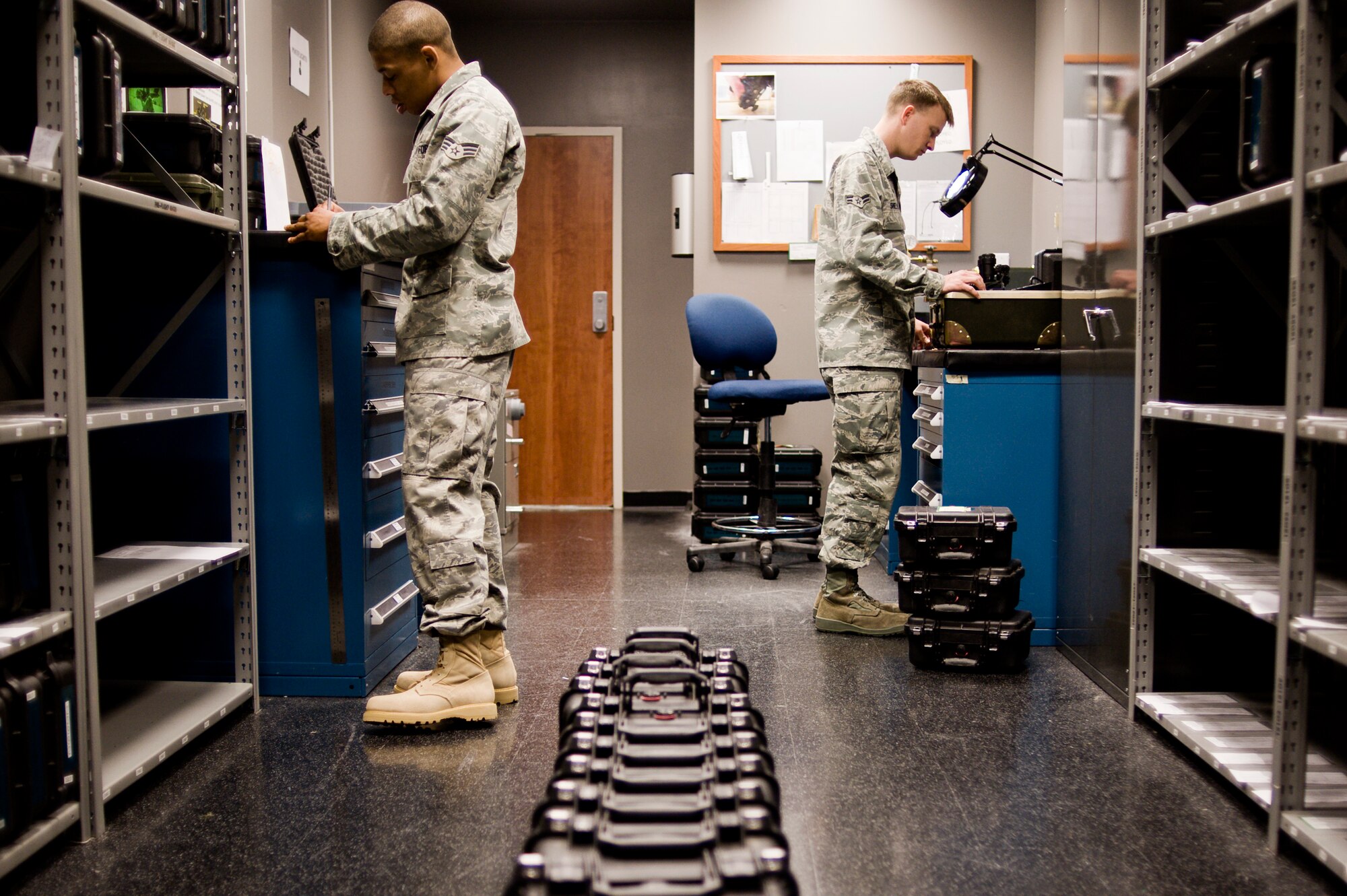 Senior Airman Zackery Riley, left, and Airman First Class Sascha Shelton, 62nd Operations Support Squadron, inventory and calibrate night-vision goggles at the 62nd OSS Aircrew Flight Equipment NGV testing room April 21 in preparation for an upcoming deployment. (U.S. Air Force Photo by Abner Guzman)