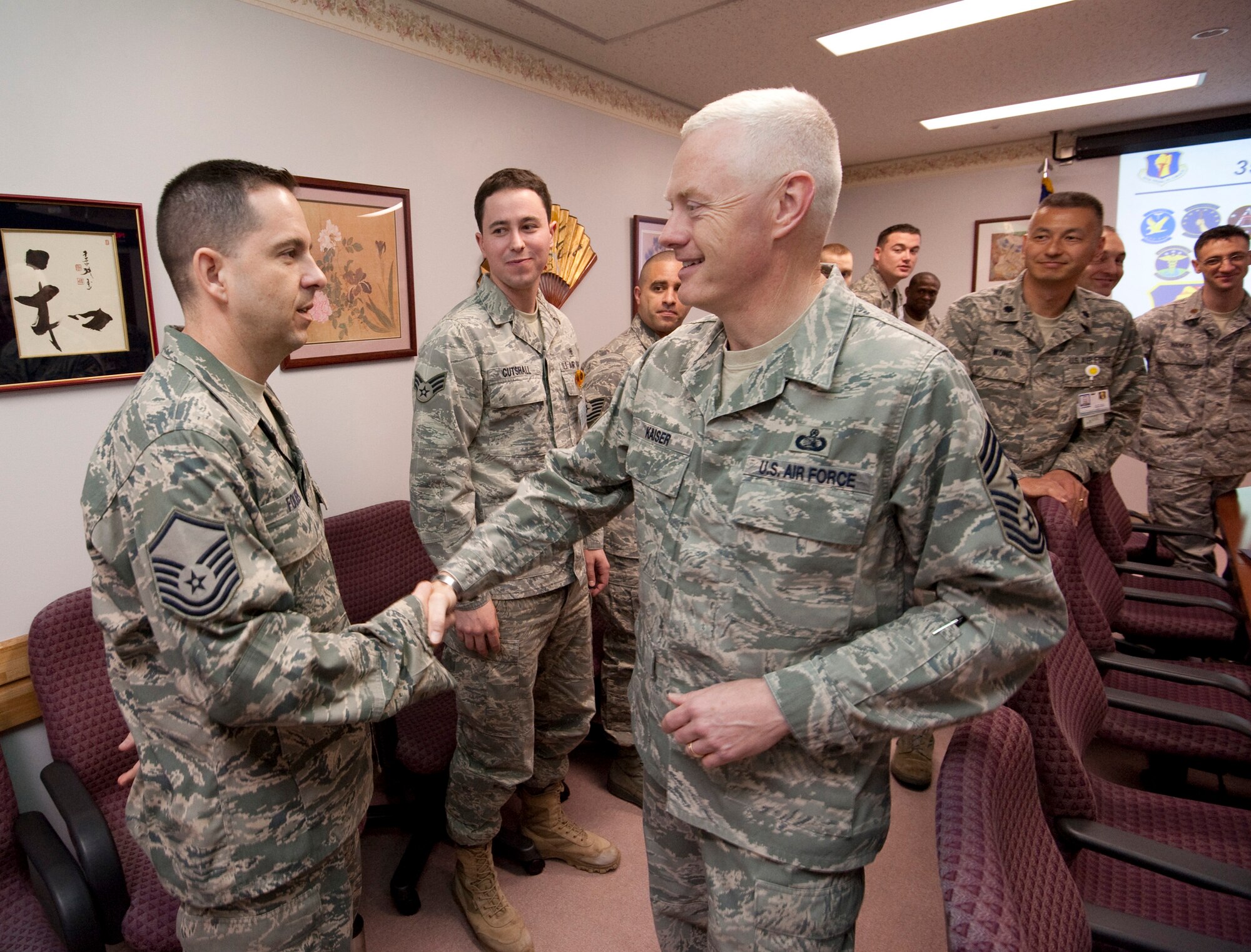 MISAWA AIR BASE, Japan -- Chief Master Sgt. Richard Kaiser, 5th Air Force command chief master sergeant, shakes hands with Master Sgt. Mark Fousek, 35th Medical Group 2009 senior NCO of the year and pharmacy flight chief, during a tour of the hospital April 21. Chief Kaiser entered the Air Force in 1984 as an environmental health specialist. (U.S. Air Force photo/Staff Sgt. Samuel Morse)