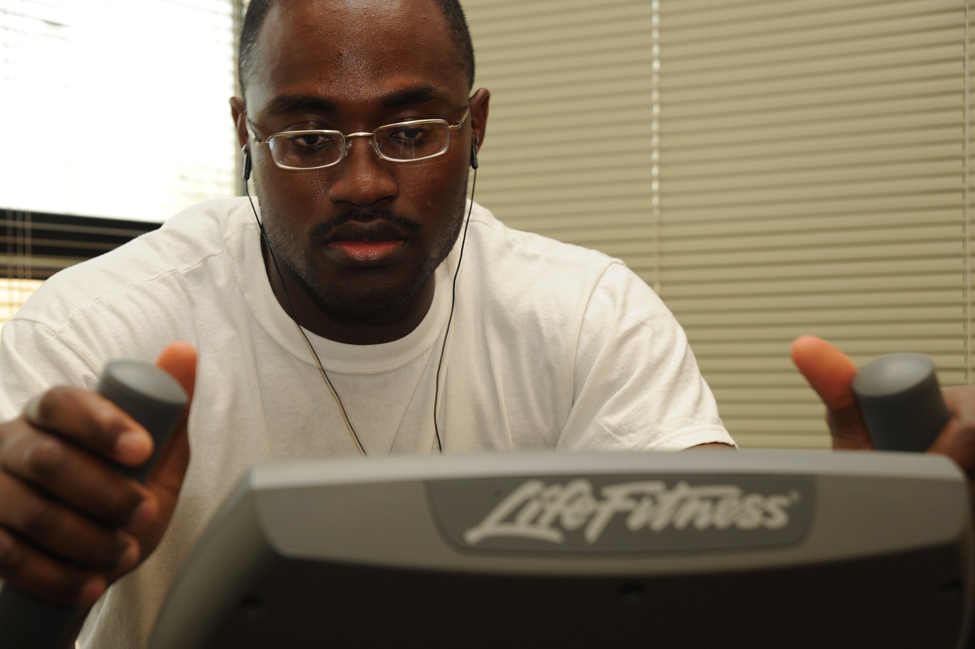 MCCONNELL AIR FORCE BASE, Kan. -- Airman 1st Class Mohamed Sillah, 22nd Force Support Squadron, rides a stationary bike during the Libray Fitness Cycle Throwdown, April 12-16, 2010, McConnell Air Force Base, Kan. McConnell Library competed with 18 Air Force bases. Team and individuals signed up to ride the fitness cycles and read or listen to audio books during the challenge. Airman Sillah rode 22.23 miles during the competition. (U.S. Air Force photo/Tech. Sgt. Chyrece Campbell)