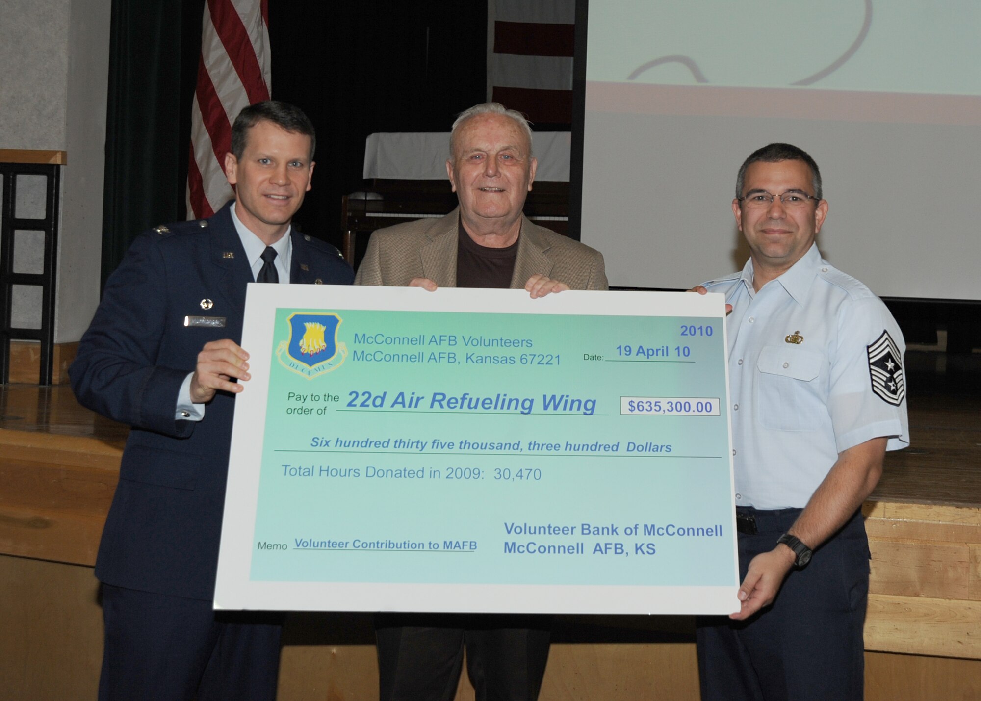 Paul Ward, McConnell Retiree Activities officer, presents Col. James Crowhurst, 22nd Air Refueling Wing commander, and Chief Master Sgt. Timothy Horn, 22nd Air Refueling Wing command chief, with a $635,003 check that represents the money the base saved due to volunteer efforts, April 19, 2010, McConnell Air Force Base, Kan. The check was presented during the 19th Annual Volunteer Appreciation Ceremony. Team McConnell members worked approximately 30,470 volunteer service hours in 2009. (U.S. Air Force photo/Senior Airman Maria Ruiz)