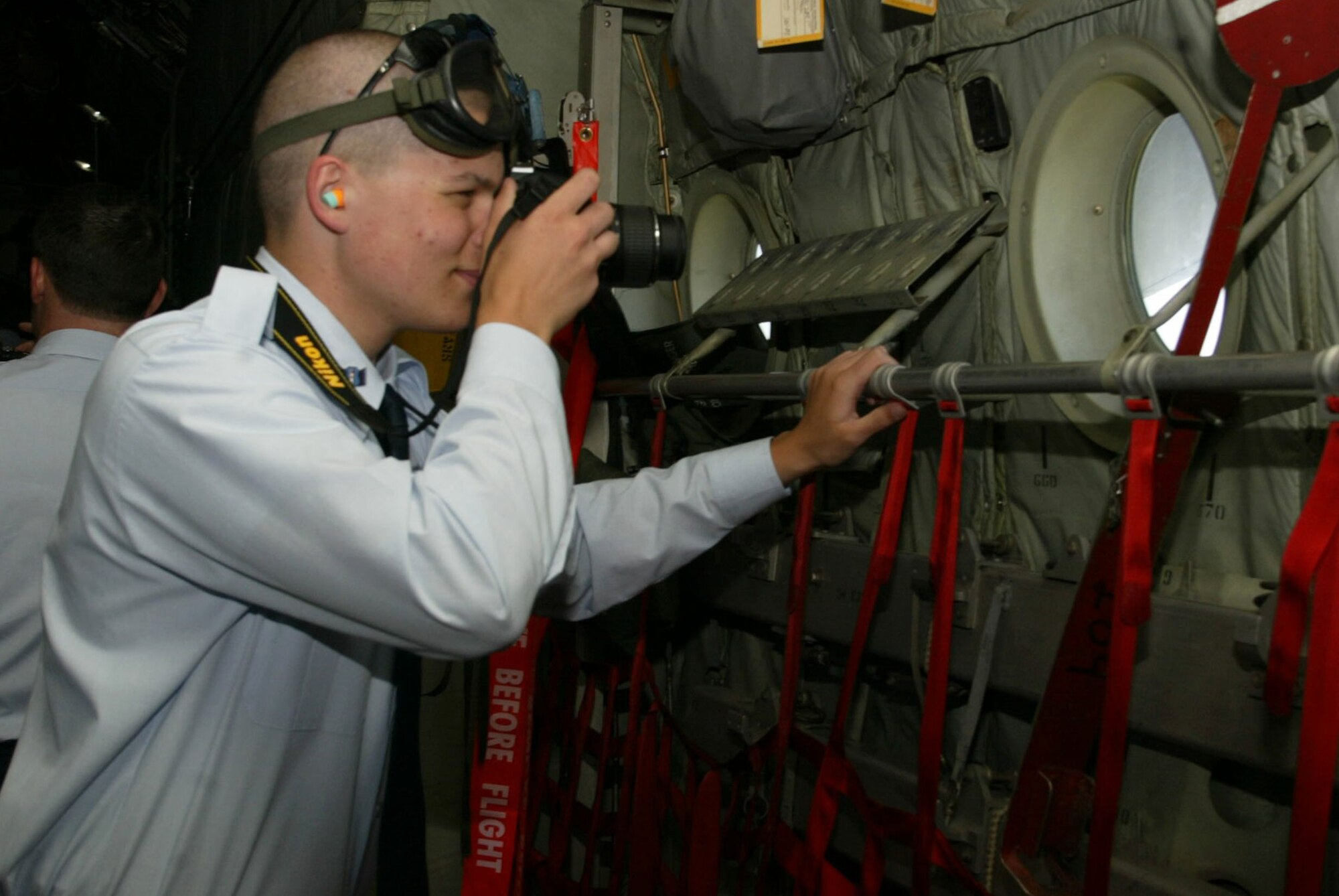 An Air Force JROTC cadet takes a photo of the view from a C-130 aircraft during the JROTC orientation flights April 14. Orientation flights are designed to introduce youth to general aviation and military opportunities through hands-on interaction with aircraft, equipment and personnel. (U.S. Air Force photo/Don Peek)