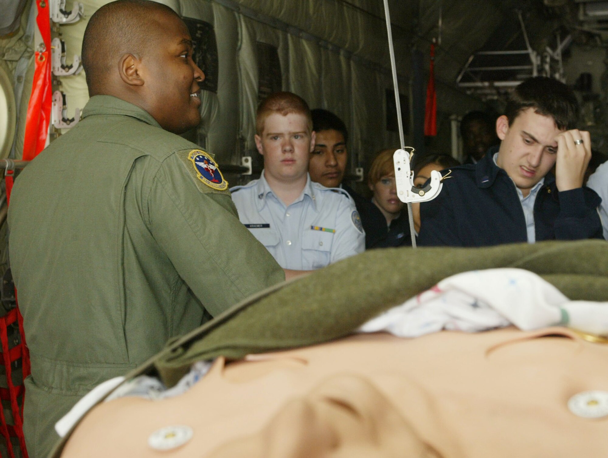 At a static display by the 94th Aermedical Evacuation Squadron, Senior Airman Carl Matthews receives varied reactions from cadets as he briefs them on the mission of aermedical evacuation teams. Students from various high schools had the opportunity to visit Dobbins Air Reserve Base during the 2010 JROTC orientation flights held here April 14. Orientation flights are designed to introduce youth to general aviation and military opportunities through hands-on interaction with aircraft, equipment and personnel. (U.S. Air Force photo/Don Peek)