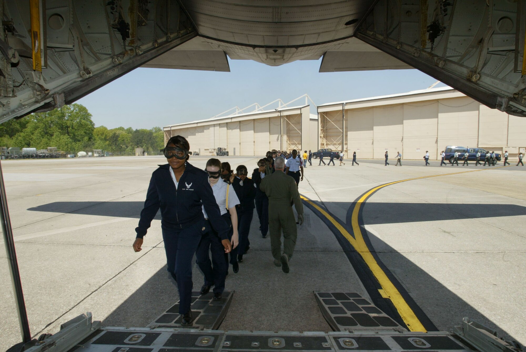 Air Force JROTC cadets, under the direction of Master Sgt. Charles Lee, loadmaster, 700th Airlift Squadron, file onto a C-130 transport aircraft in preparation of their orientation flight April 14. Orientation flights are designed to introduce youth to general aviation and military opportunities through hands-on interaction with aircraft, equipment and personnel. (U.S. Air Force photo/Don Peek)
