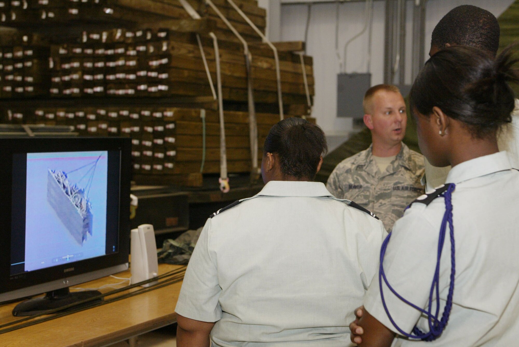 Staff Sgt. Carlos Beaver from the 94th Aerial Delivery Flight briefs a group of Army JROTC cadets about aerial delivery flight mission at the 2010 JROTC Orientation Flights April 13-14. Orientation flights are designed to introduce youth to general aviation and military opportunities through hands-on interaction with aircraft, equipment and personnel. (U.S. Air Force photo/Don Peek)