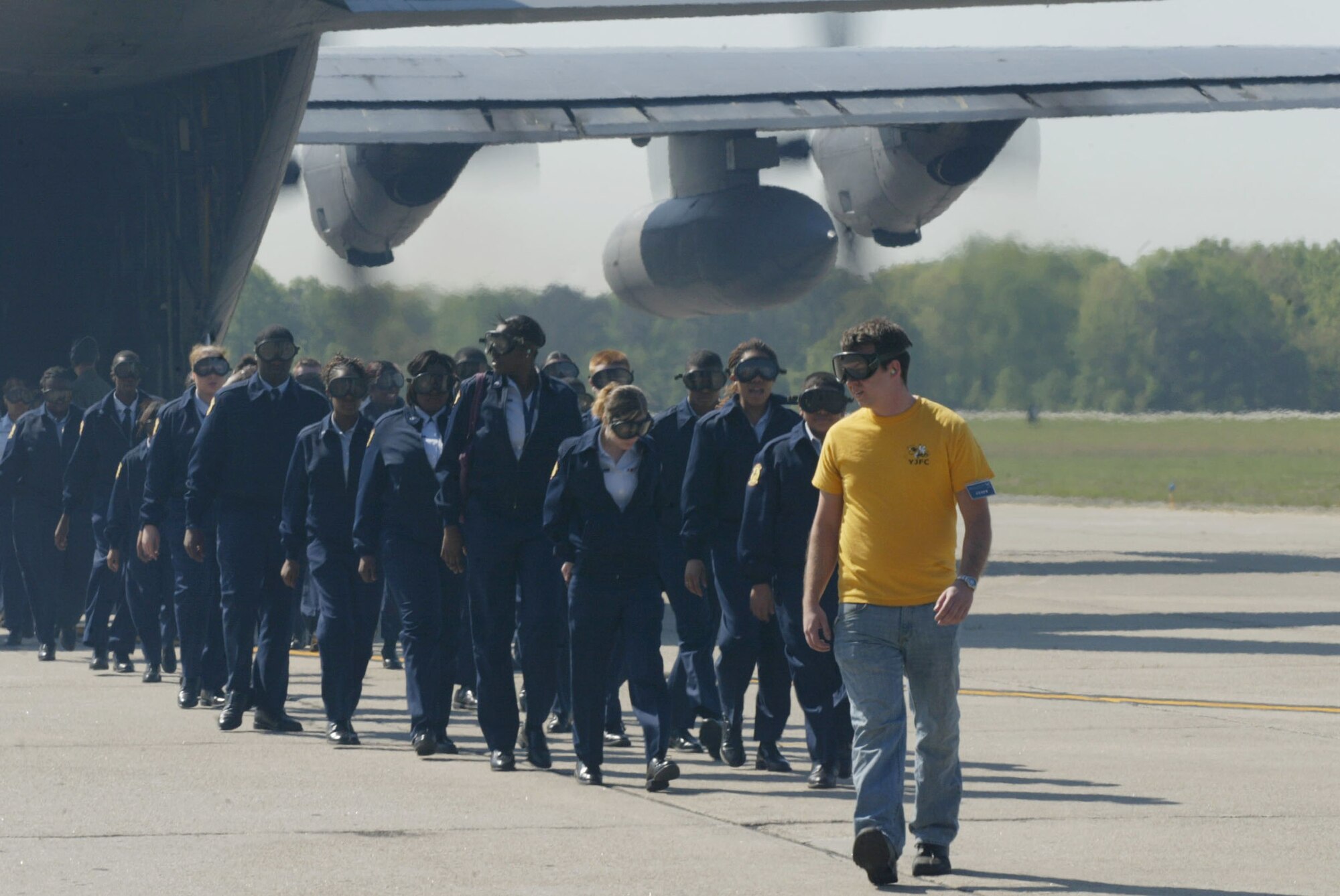 Air Force JROTC cadets are escorted from a C-130 transport aircraft by Tyler Smith, volunteer from the Georgia Institute of Technology Flying Club, after taking an orientation flight here April 13. Orientation flights are designed to introduce youth to general aviation and military opportunities through hands-on interaction with aircraft, equipment and personnel. (U.S. Air Force photo/Don Peek)