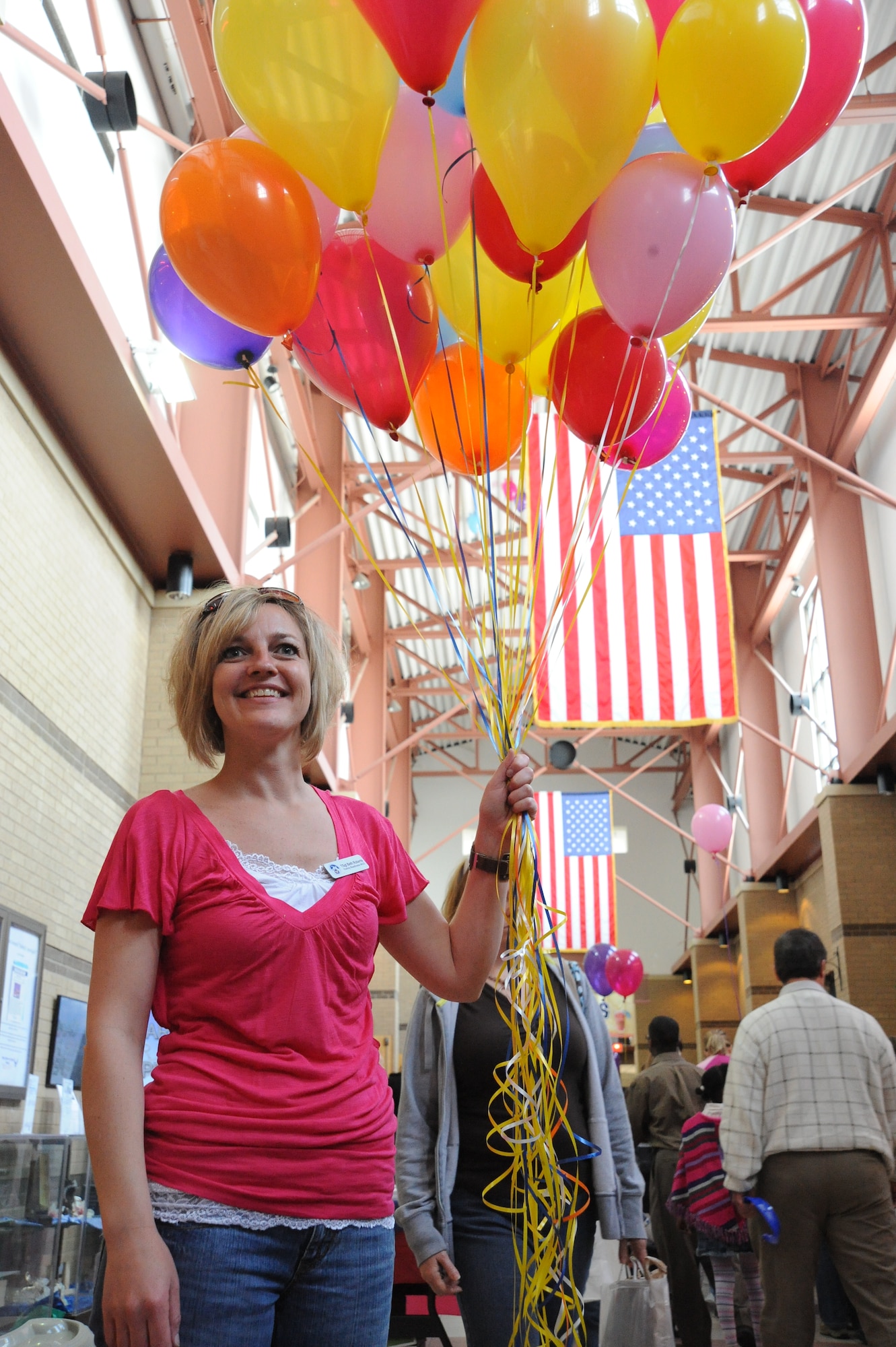 Tech. Sgt. Beth Roberts, 22nd Force Support Squadron Airman and Family Readiness Center readiness NCO, greets Team McConnell members with balloons during the Family Festival of Fun, April 17, 2010, McConnell Air Force Base, Kan. The 22nd FSS Airmen and Family Services Flight hosted the event in conjunction with the Month of the Military Child. Activities for all ages included inflatables, crafts, games, petting zoo, car seat safety check and entertainment. (U.S. Air Force photo/Tech. Sgt. Chyrece Campbell)