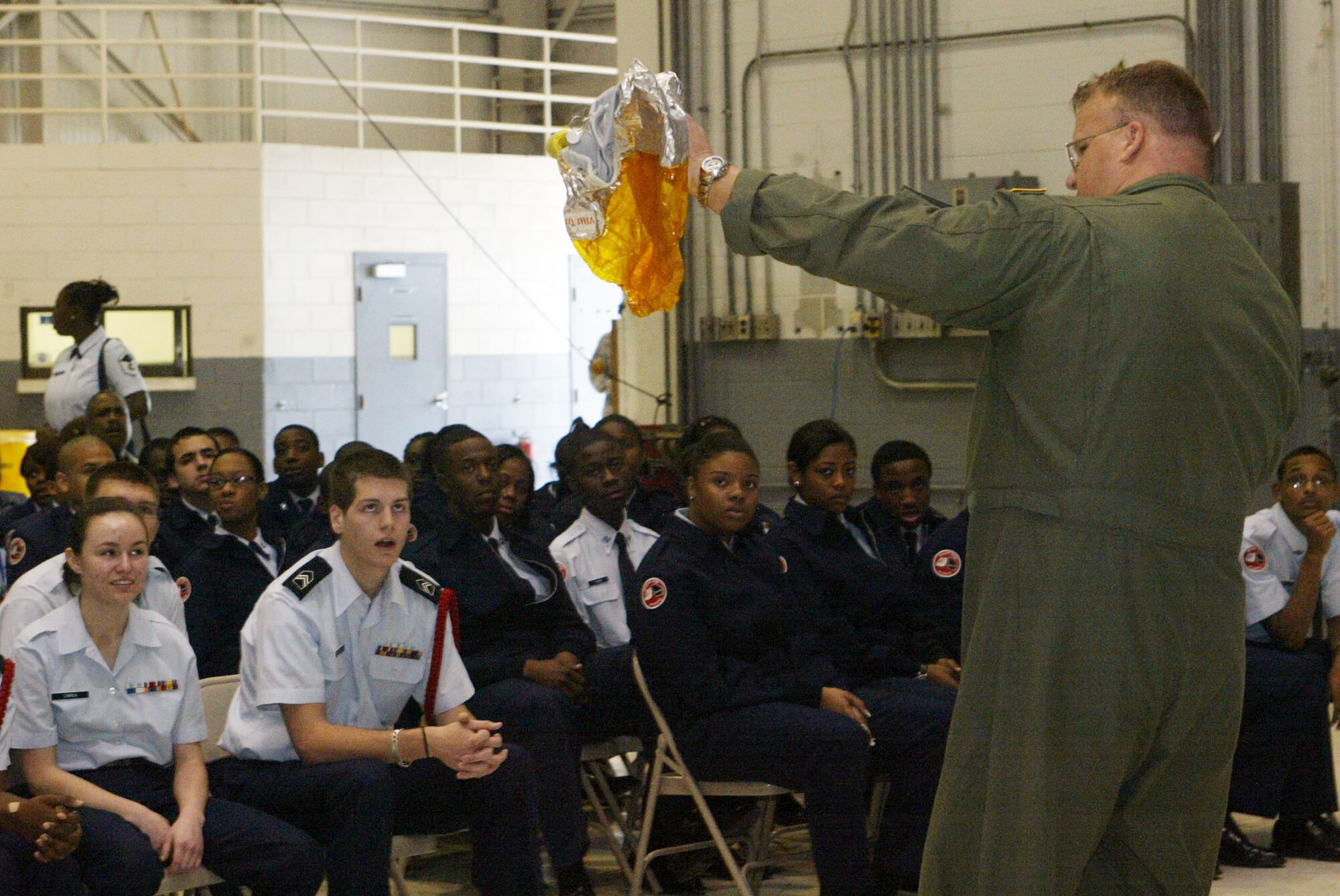 Air Force JROTC cadets watch as they receive their pre-flight briefing from Master Sgt. Richard Graddy, loadmaster, 700th Airlift Squadron as they prepare to take their orientation flight April 13. Orientation flights are designed to introduce youth to general aviation and military opportunities through hands-on interaction with aircraft, equipment and personnel. (U.S. Air Force photo/Don Peek)