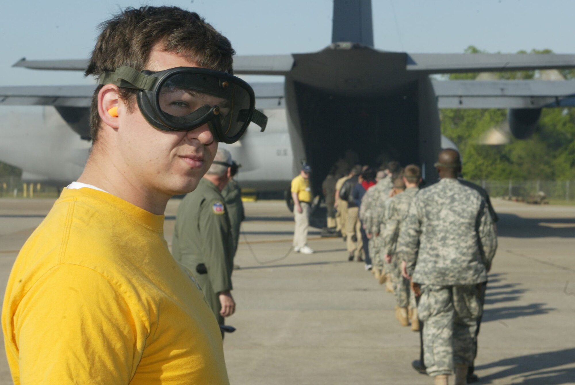 Tyler Smith, a volunteer from the Georgia Institute of Technology Flying Club, assists flight crews as Navy JROTC cadets from McEachern High School and members of the Army Cadet Corps of Atlanta board a C-130 aircraft in preparation of their orientation flight here April 13. Orientation flights are designed to introduce youth to general aviation and military opportunities through hands-on interaction with aircraft, equipment and personnel. (U.S. Air Force photo/Don Peek)