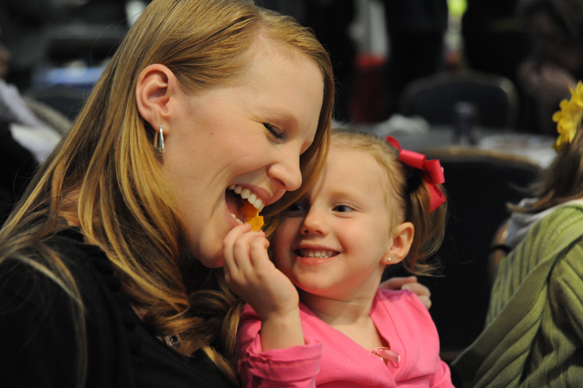 Brynlee Lloyd, 4-year-old, shares food with her mother Tara Lloyd, Team McConnell family member, during the Family Festival of Fun, April 17, 2010, McConnell Air Force Base, Kan. More than 3,000 Team McConnell members attended the festival. This was the 12th year that the 22nd FSS Airmen and Family Services Flight hosted the event. (U.S. Air Force photo/Tech. Sgt. Chyrece Campbell)