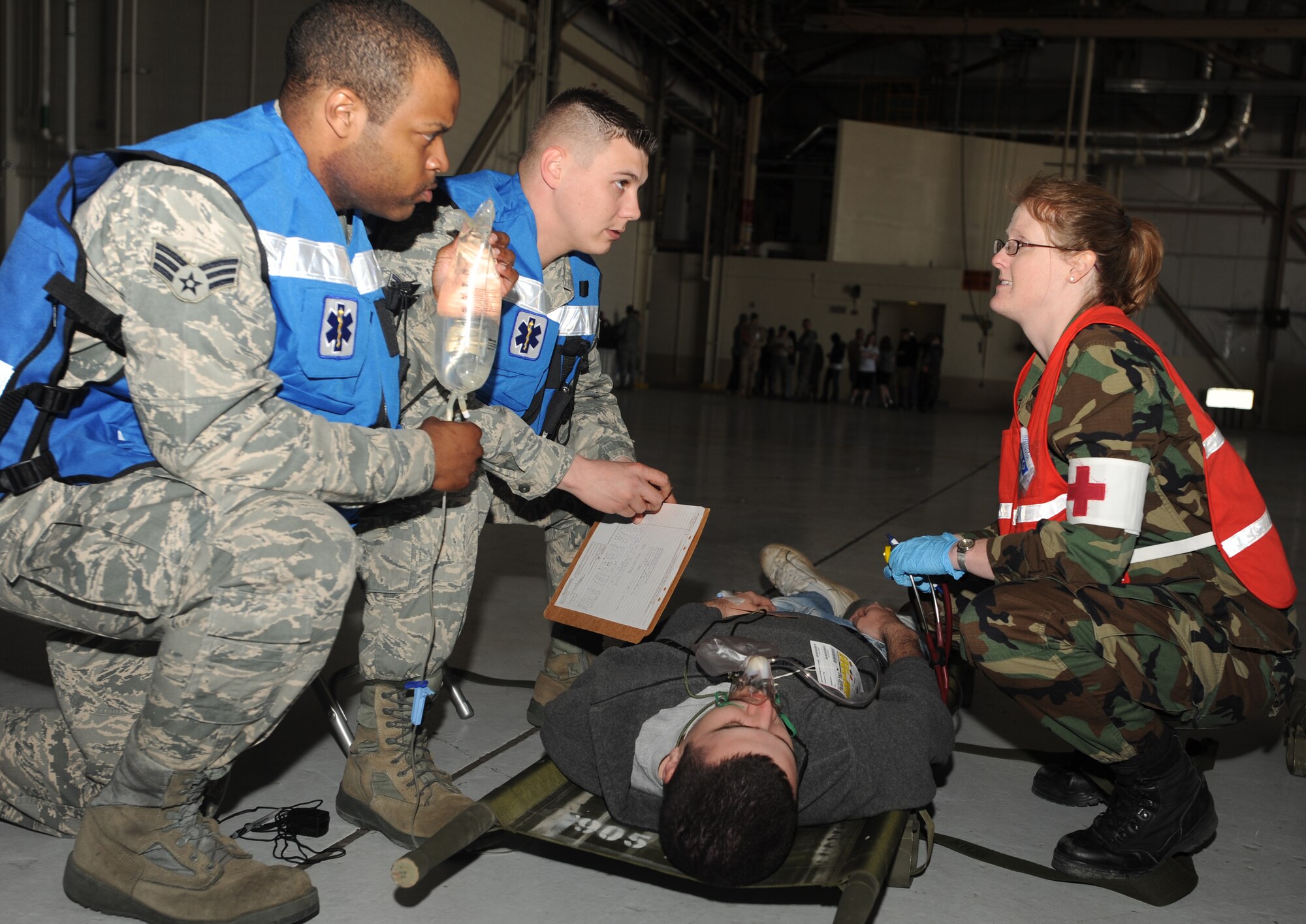 Senior Airman Brison King, Airman 1st Class Austin Thomas and Capt. Amanda Adams, all with the 319th Medical Group, discuss the best course of treatment for an “injured” spectator during a Major Accident Response Exercise April 20 at Grand Forks Air Force Base, N.D. The MARE was designed to test the base’s ability to respond to a major incident and is just one of the ways the base is preparing for its upcoming Air Show. (U.S. Air Force photo by Staff Sgt. Suellyn Nuckolls)