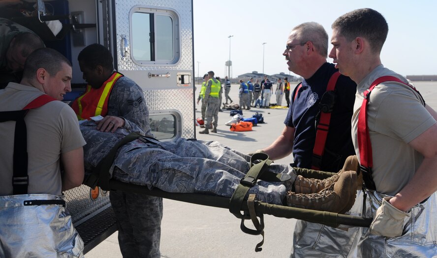 Airmen from the 319th Air Refueling Wing and a civilian with the 319th Civil Engineer Squadron load a “patient” into the back of an ambulance during a Major Accident Response Exercise April 20 at Grand Forks Air Force Base, N.D. The MARE was designed to test the base’s ability to respond to a major incident and is just one of the ways the base is preparing for its upcoming Air Show. (U.S. Air Force photo by Staff Sgt. Suellyn Nuckolls)