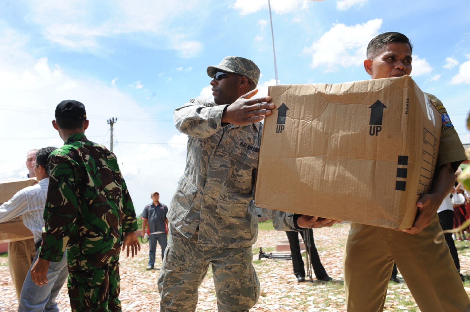 Airman 1st Class Brian Ellis passes a box of donated clothes, toys and sports equipment to the Negeri Gembor 2 Elementary School headmaster April 21 in the Lanud Gorda Binuang area of Indonesia.  The donations came from Yokota Air Base, Japan, where Airman Ellis is assigned to the 374th Logistics Readiness Squadron.  He and other Yokota Airmen are participating in Cope West 10, a Pacific Air Forces-sponsored bilateral tactical airlift exercise involving the U.S. and Indonesian air forces. The exercise is designed to advance interoperability between the two services, and promote cooperation and unity of purpose. (U.S. Air Force photo/Tech Sgt. Cohen A. Young)