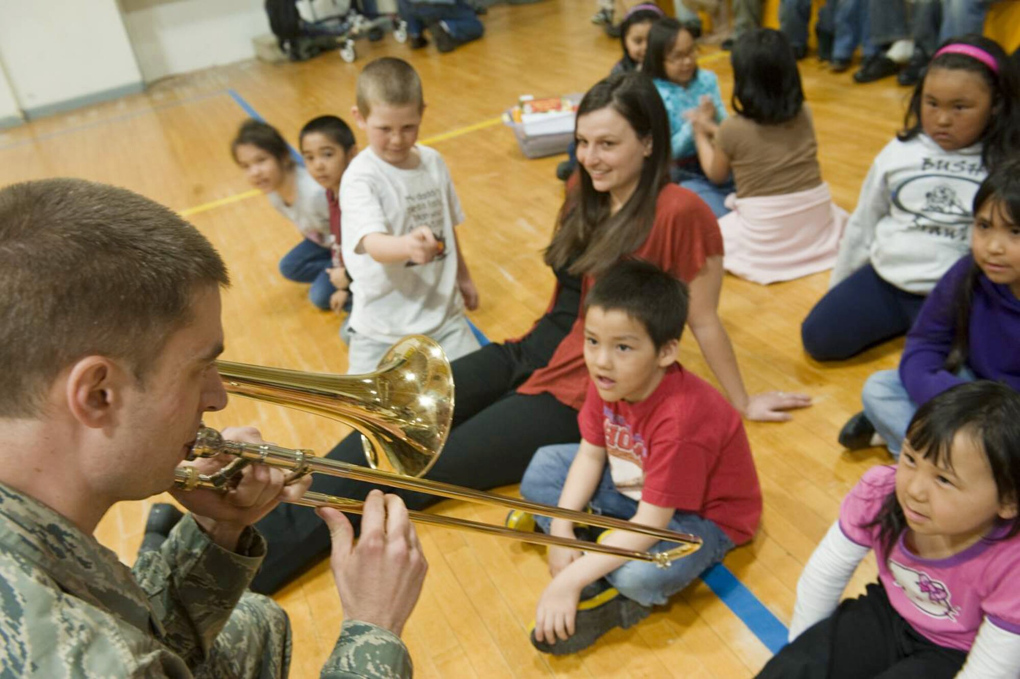 A musician from the Pacific Air Forces Northern Lights brass ensemble speaks with Kotzebue elementary students during Operation Artic Care about his trombone April 20, 2010, in Kotzebue, Alaska. (U.S. Air Force photo/Senior Airman Christopher Griffin)
