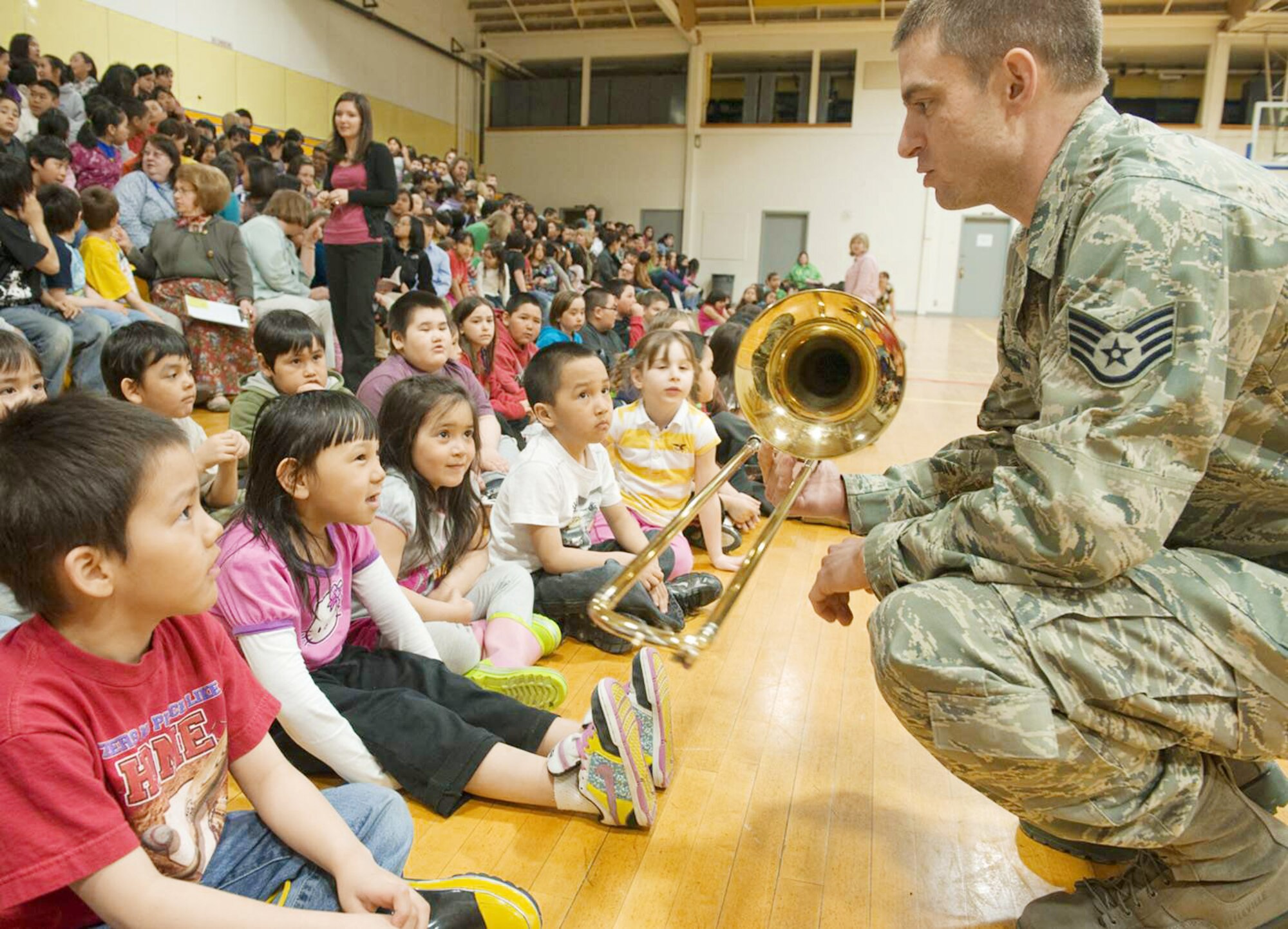 A musician from the Pacific Air Forces Northern Lights brass ensemble speaks with Kotzebue elementary students during Operation Artic Care about his trombone April 20, 2010, in Kotzebue, Alaska. (U.S. Air Force photo/Senior Airman Christopher Griffin)