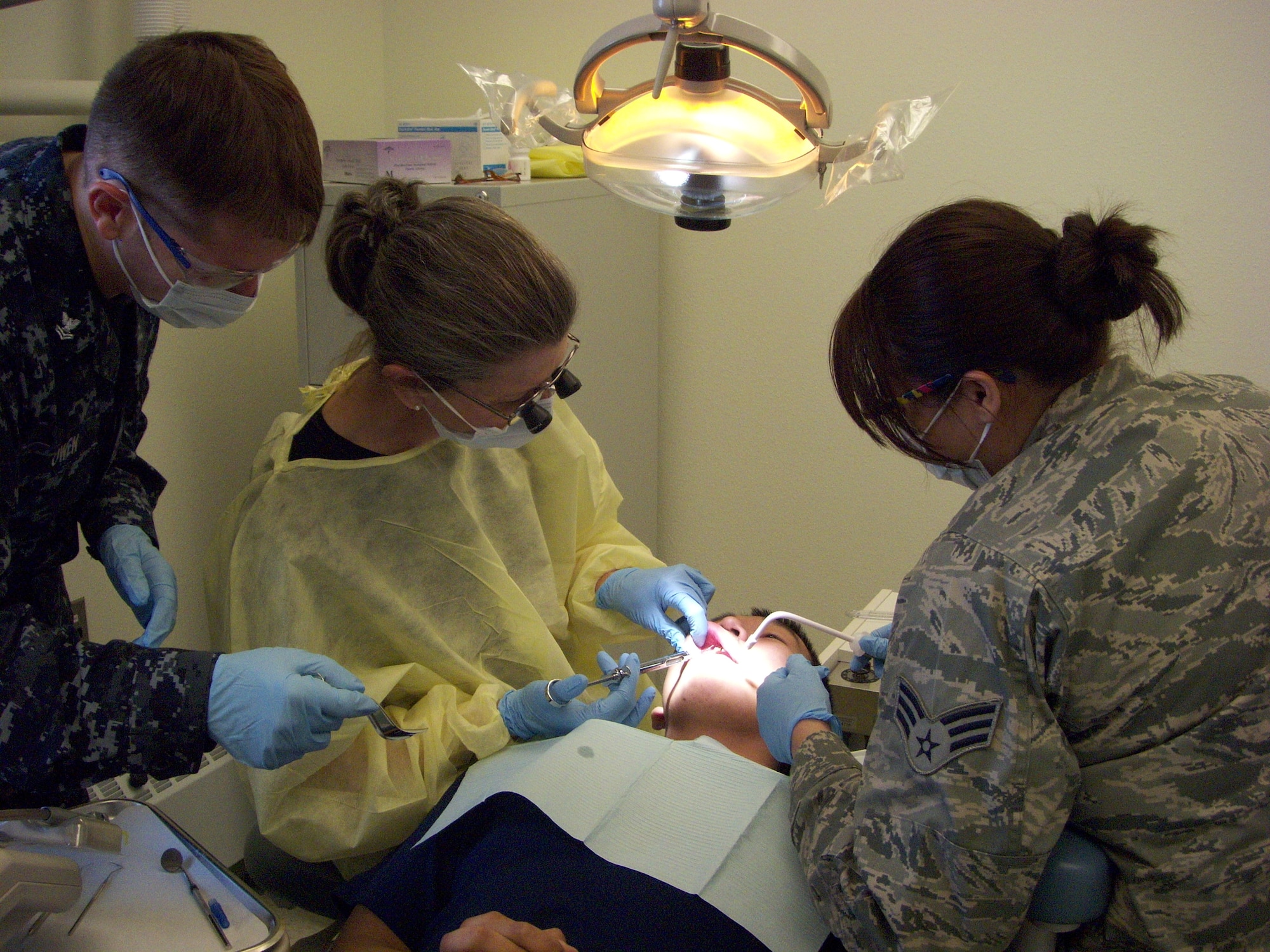 Lt. Col. Frances McClure, dentist with the 916th Aerospace Medicine Flight, Hospital Midshipman Tim Owen fro Camp Lejeune and Senior Airman Samantha Crawford from Lackland AFB, Texas, work on a patient in Alaska as part of Artic Care 2010. (USAF photo courtesy of 916 AMDF)