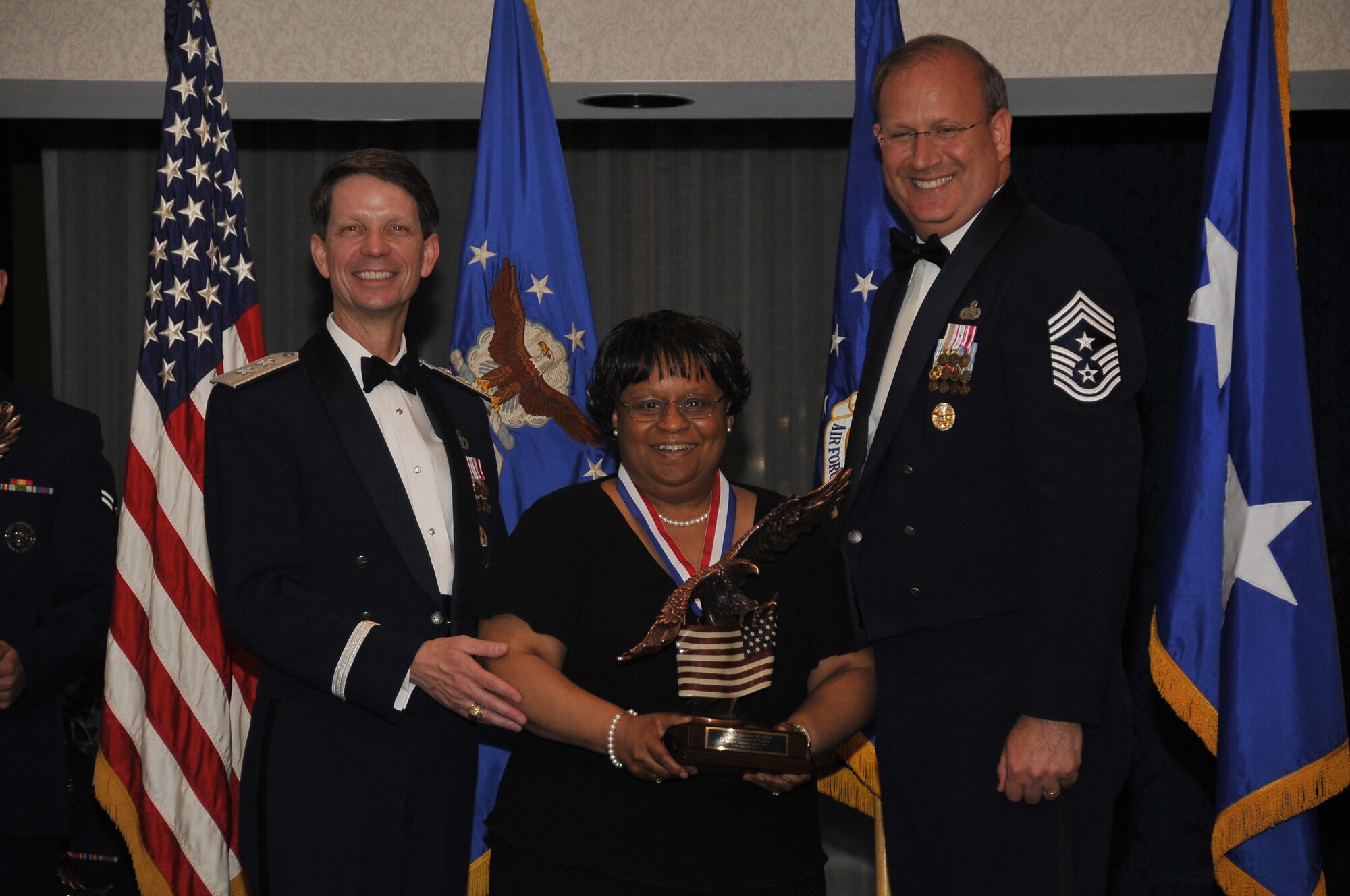 Air Force District of Washington Commander Maj. Gen. Darrell D. Jones, left, and AFDW Command Chief Master Sgt. Pat Battenberg, right, presented the AFDW the 2009 Annual  Volunteer of the Year award to Ms. Jacqueline Randall, 11th Civil Engineering Squadron, Bolling, during the AFDW Annual Awards Banquet April 16, 2010. The banquet was held at the Bolling Club, Bolling AFB, Washington D.C. (U.S. Air Force photo by Senior Airman Marleah Miller)