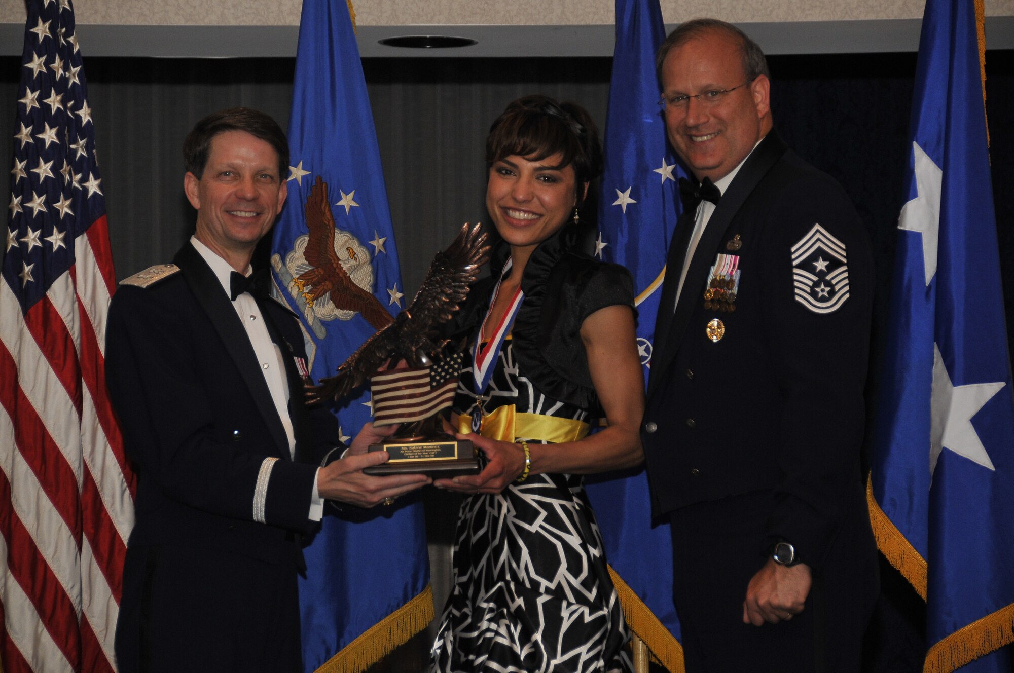 Air Force District of Washington Commander Maj. Gen. Darrell D. Jones, left, and AFDW Command Chief Master Sgt. Pat Battenberg, right, presented the  AFDW the 2009 Annual  Civilian of the Year Category l Award to Ms. Sabine S. Martinez,  316th Wing, Force Support  Squadron, Andrew during the AFDW Annual Awards Banquet April 16, 2010. The banquet was held at the Bolling Club, Bolling AFB, Washington D.C. (U.S. Air Force photo by Senior Airman Marleah Miller)