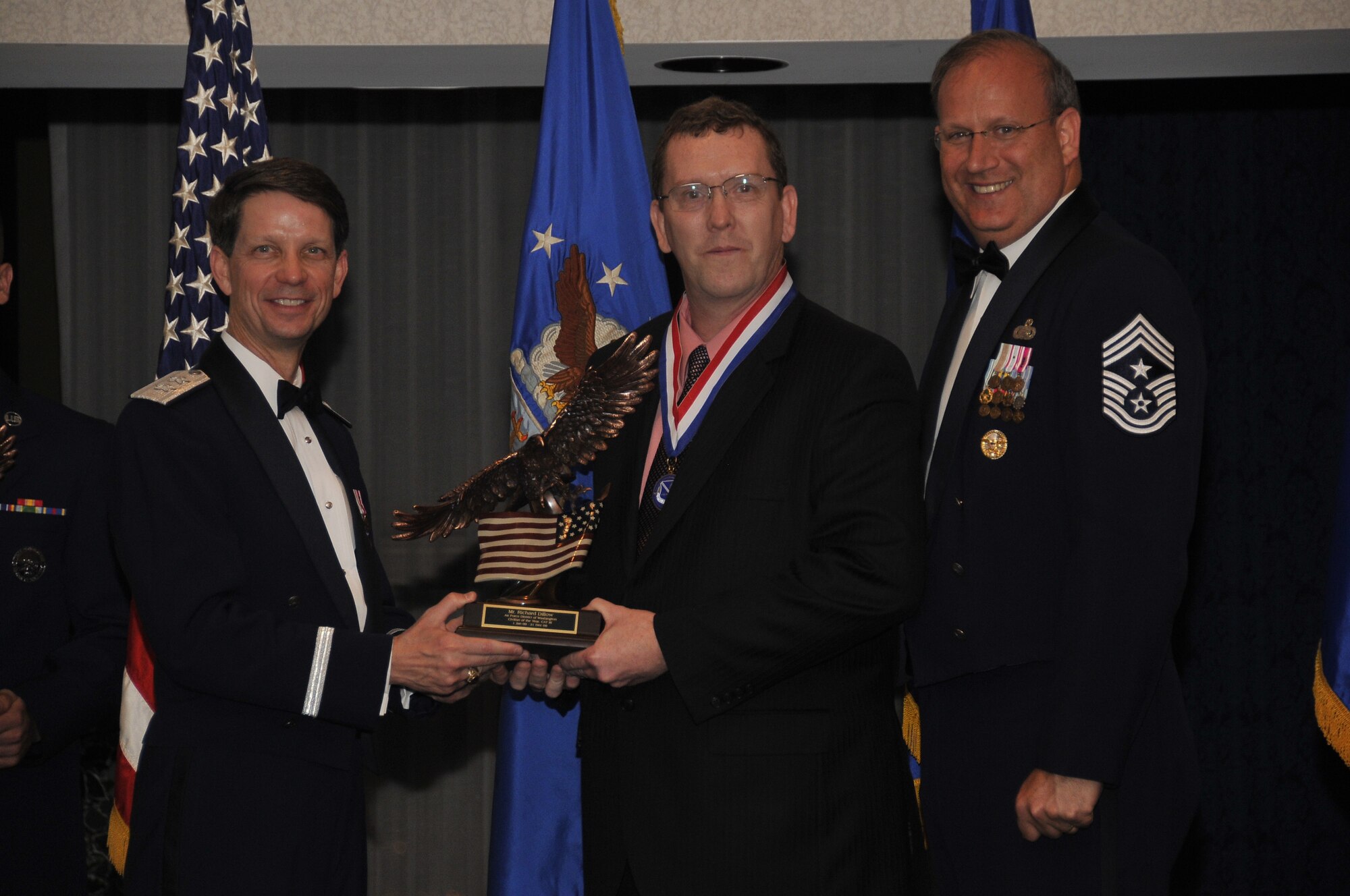 Air Force District of Washington Commander Maj. Gen. Darrell D. Jones, (left) and AFDW Command Chief Master Sgt. Pat Battenberg, (right) present the AFDW 2009 Annual  Civilian of the Year Category III Award to Mr. Richard Dillow, (center) chief AFDW Financial Accounting Operations, Andrews AFB,  Md., during the AFDW Annual Awards Banquet April 16, 2010. The banquet was held at the Bolling Club, Bolling AFB, Washington, D.C. (U.S. Air Force photo by Senior Airman Marleah Miller) 