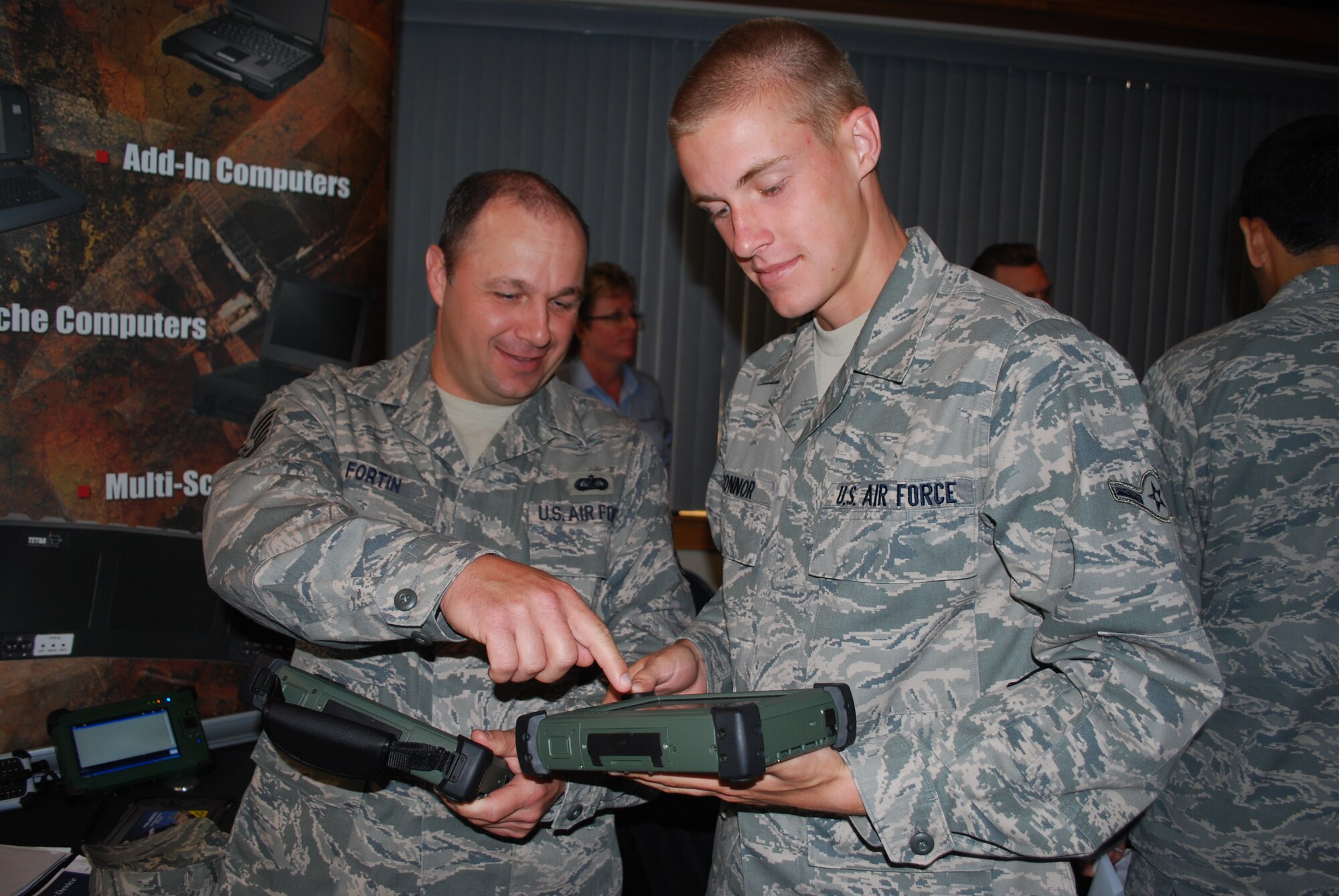 Tech. Sgt. Tod Fortin and Airman Michael O'Connor of the Air Force Technical Applications Center compare field computers at the Patrick Air Force Base Technology Expo April 21 at The Tides. Organized by the Cape Canaveral Chapter of the Armed Forces Communications and Electronics Association, approximately 25 vendors turned out to showcase their wares. (U.S. Air Force photo/Senior Airman David Dobrydney)