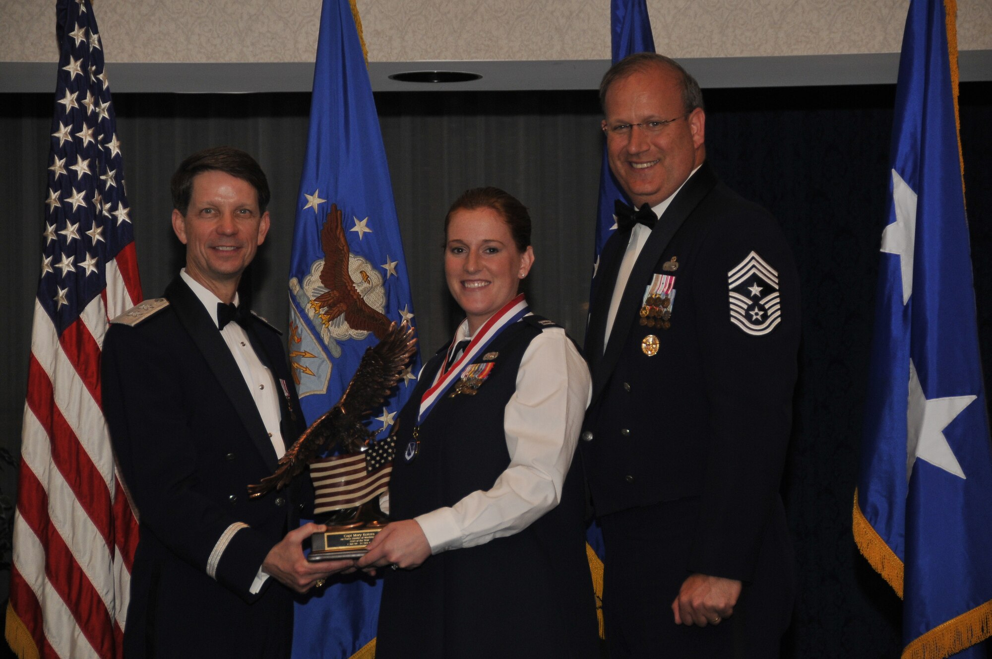 Air Force District of Washington Commander Maj. Gen. Darrell D. Jones, left, and AFDW Command Chief Master Sgt. Pat Battenberg, right, presented the AFDW the 2009 Annual Company Grade Officer of the Year award to Capt. Mary K. Kotora AFDW Security Forces, Andrews during the AFDW Annual Awards Banquet April 16, 2010. The banquet was held at the Bolling Club, Bolling AFB, Washington D.C. (U.S. Air Force photo by Senior Airman Marleah Miller)