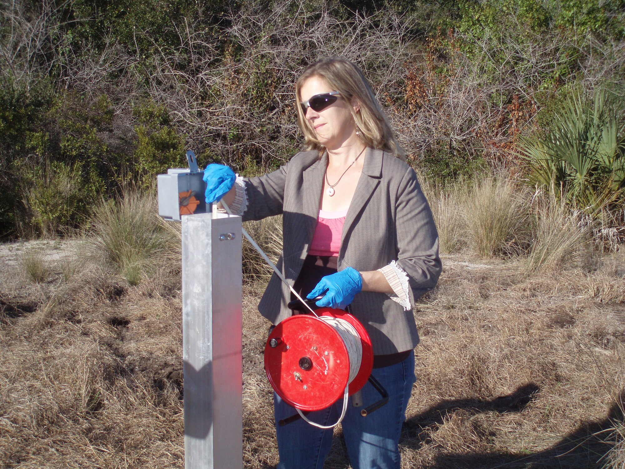 Regina Butler, a recent recipient of the 2010 Secretary of Defense Environmental Award for Environmental Restoration, measures ground water level from a monitoring well at CCAFS, to help determine water flow direction. Ms. Butler is assigned to the 45th Civil Engineer Squadron and has been working for the squadron for about a dozen years. (U.S. Air Force photo/Lindsay Morgan)
