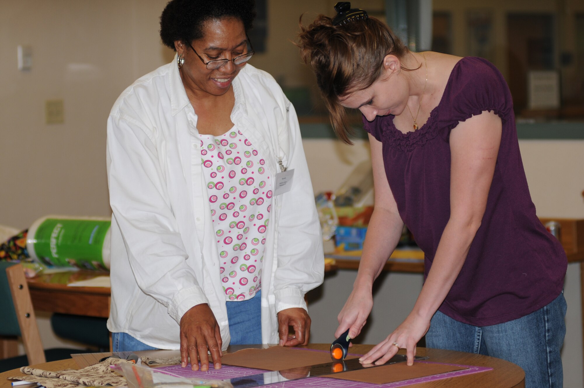 Quilting instructor Marietta Johnson assists Angela Motte as she cuts fabric during a quilting class at McBride Library April 17 as part of National Library Week.   Mrs. Motte is married to Tech. Sgt. Jason Motte, 333rd Training Squadron.  (U.S. Air Force photo by Kemberly Groue)
