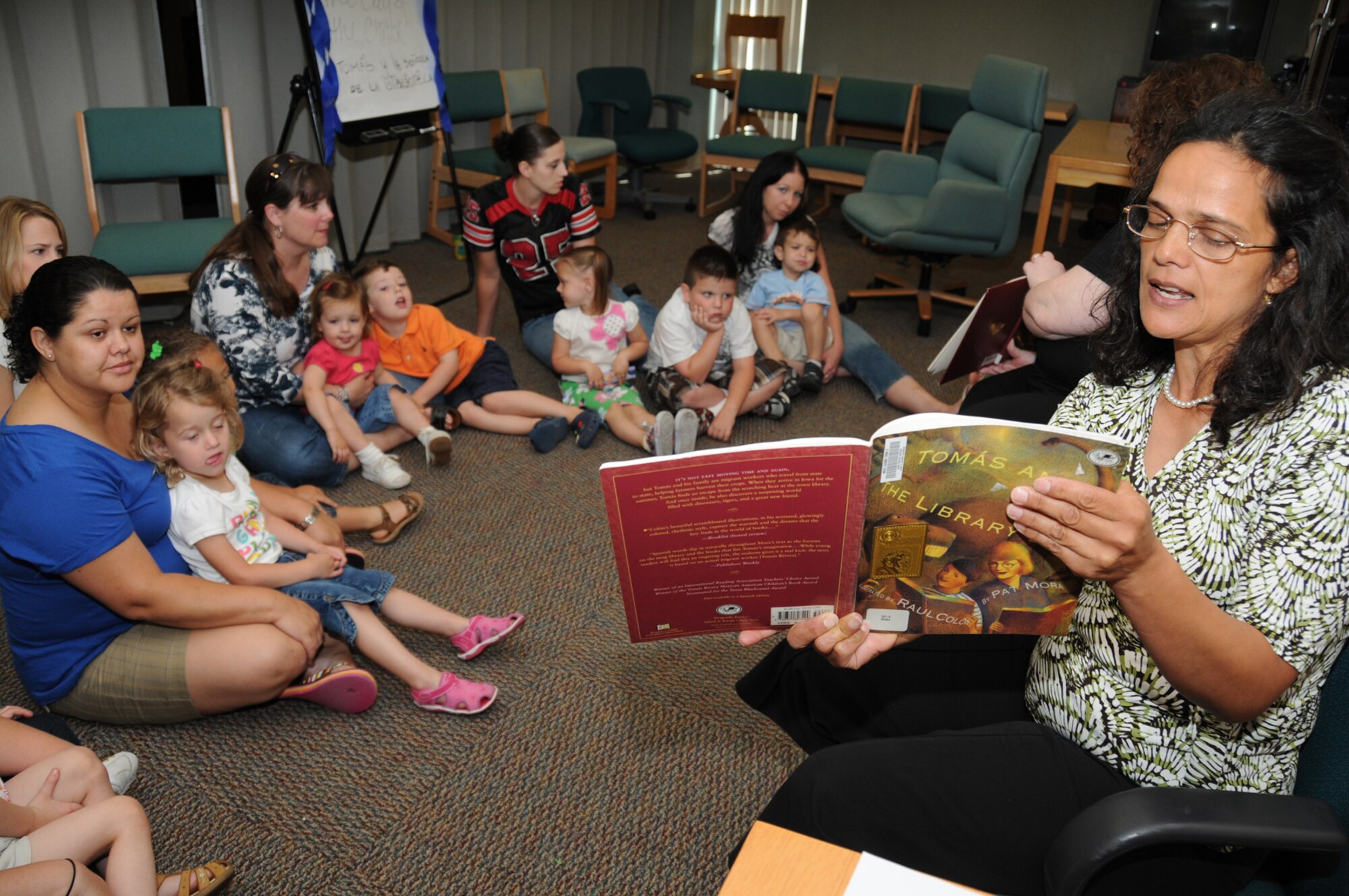 Volunteer Mireya Alexander reads "Tomas and the Library Lady" during a children's story time at McBride Library April 14 as part of National Library Week.  Her husband, Ron, is a retired major.  (U.S. Air Force photo by Kemberly Groue)