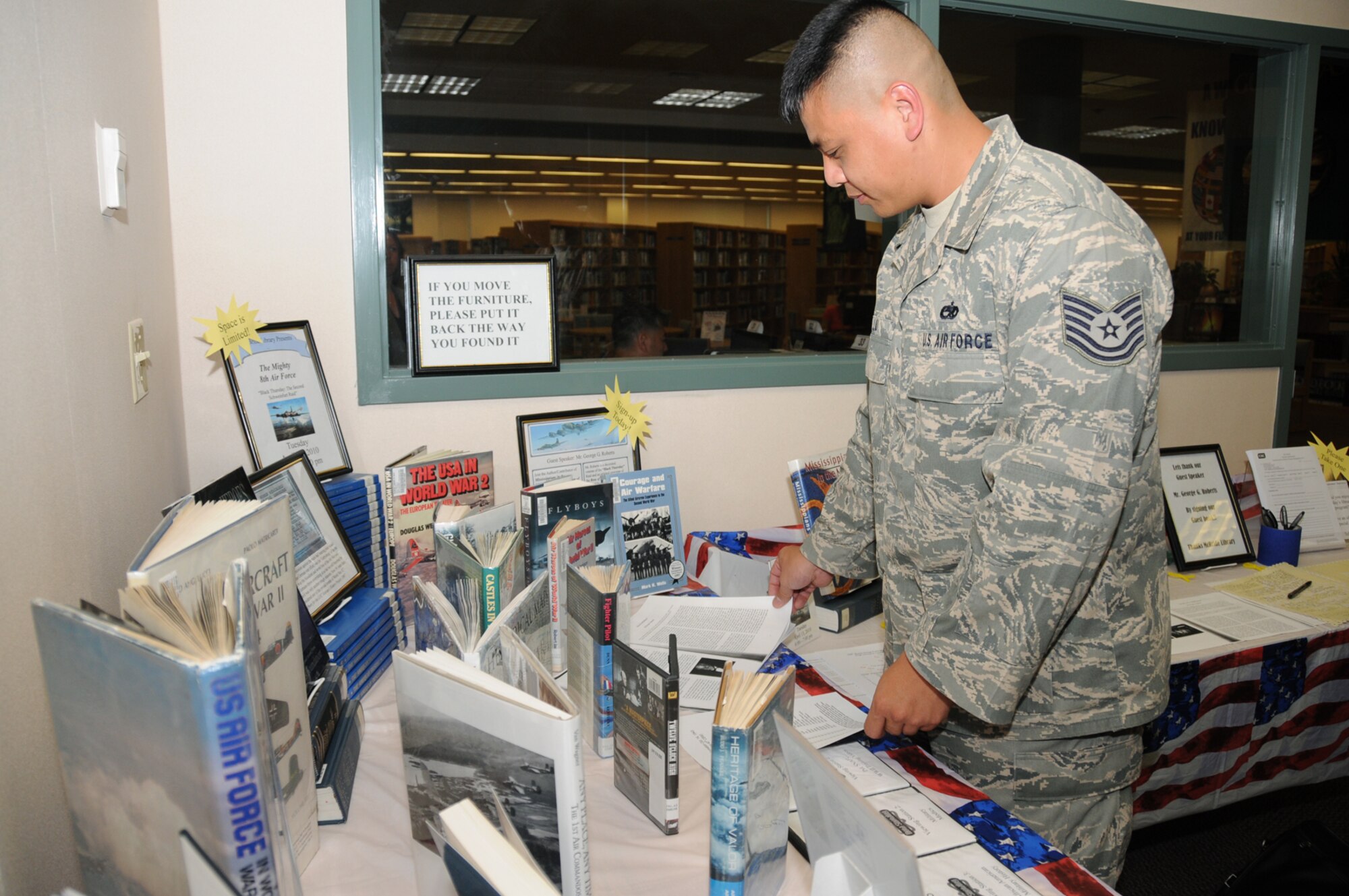 Tech. Sgt. Wai Chung Liu, 332nd Training Squadron, checks out a display of World War II books at McBride Library April 13 as part of National Library Week.  (U.S. Air Force photo by Kemberly Groue)