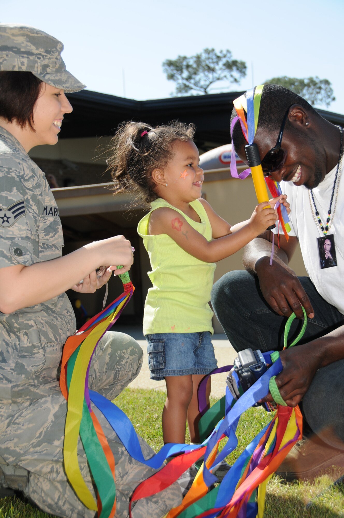 Destiny Williams, 2½, twirls streamers with her parents, Senior Airman Natalie Marchese and Antonio Barnes, during Family Fun Day at the child development center April 15. Airman Marchese is assigned to the 81st Logistics Readiness Squadron.  (U.S. Air Force photo by Kemberly Groue)