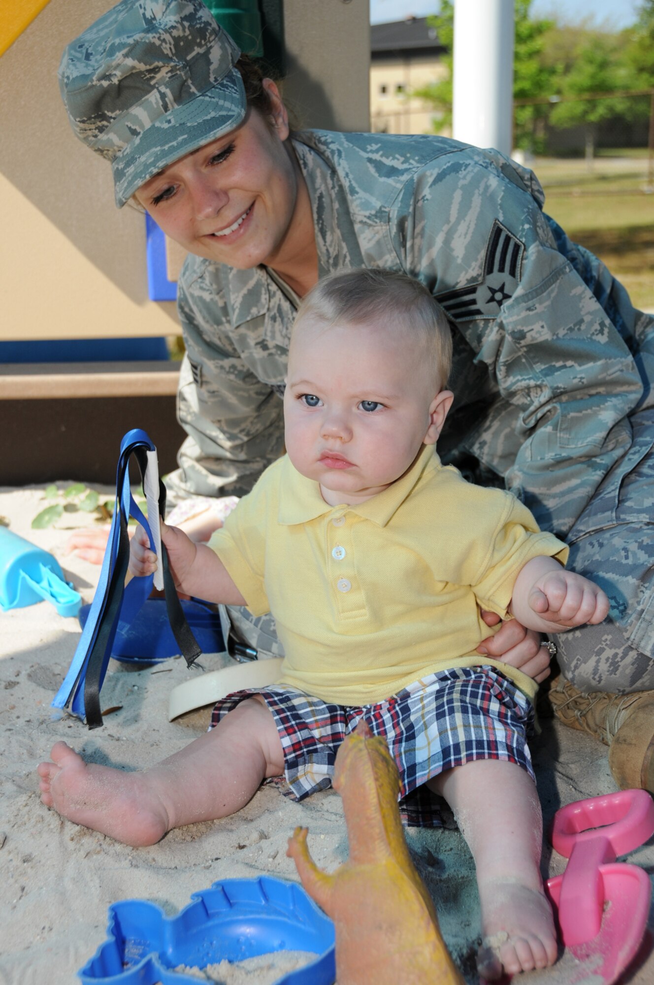 Senior Airman Julia Berger, 81st Logistics Readiness Squadron, plays in a sandbox with her 7½-month old son, Nathan Jr., at the child development center’s family fun day April 15.  Airman Berger’s husband is Petty Officer 3rd Class Nathan Berger, who’s stationed at the Seabee Base in Gulfport.  (U.S. Air Force photo by Kemberly Groue)