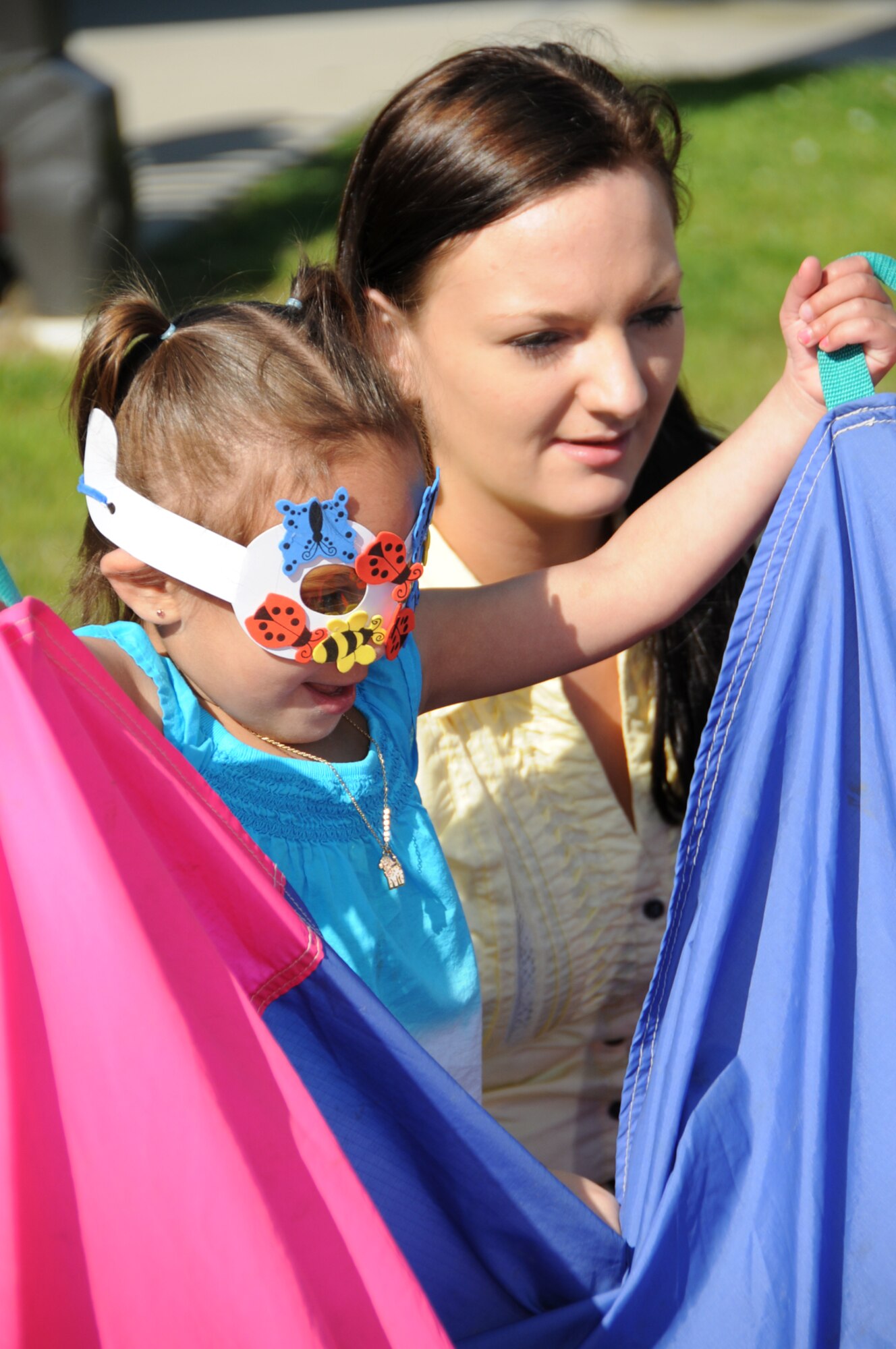 Alyiah Hall, 3, and her mother, Kellie, play with a parachute.   Dad is Senior Airman Anthony Hall, 81st Dental Squadron. (U.S. Air Force photo by Kemberly Groue)