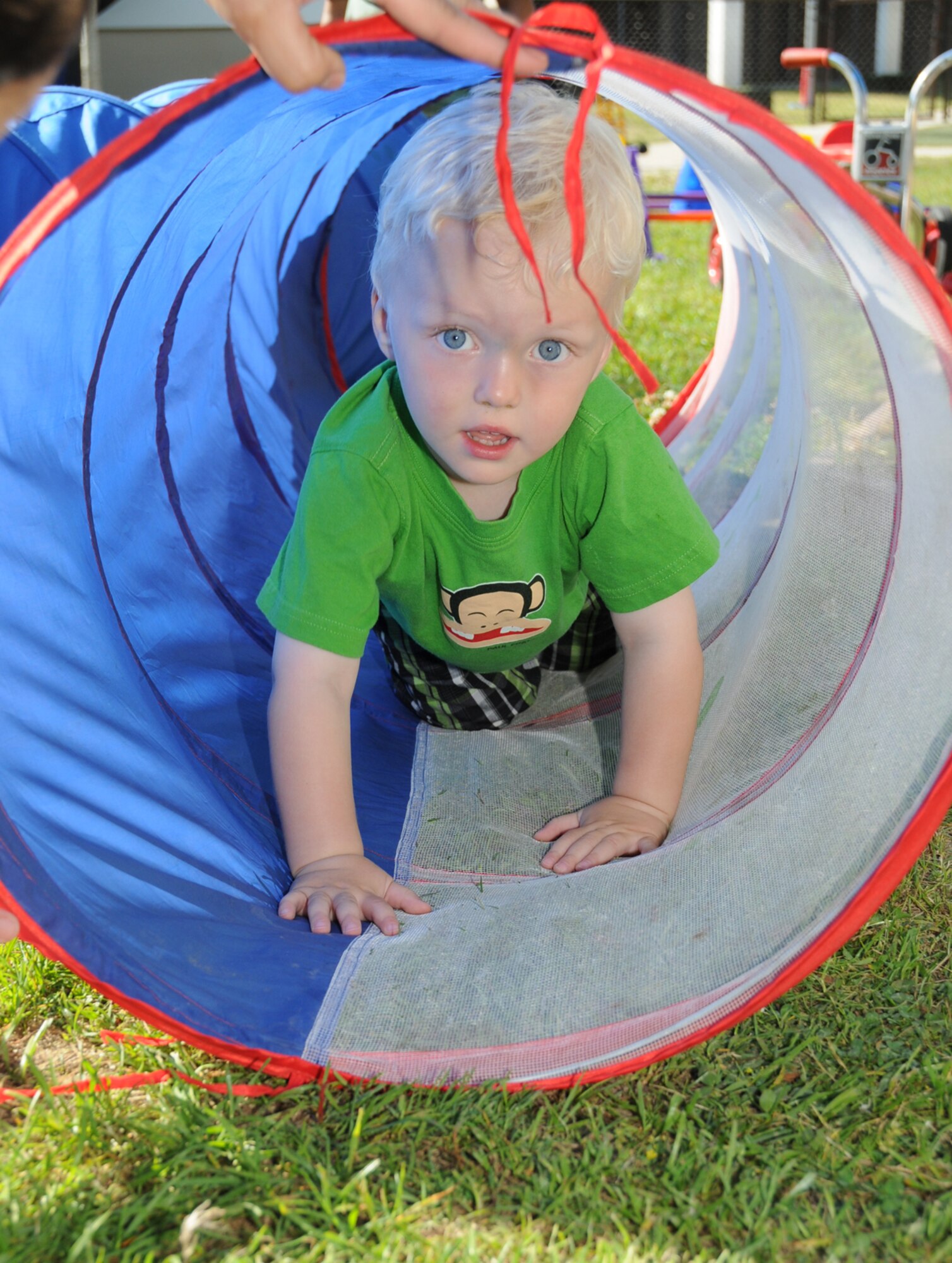 Two-year-old Trenton Peters crawls through a chute during the child development center's family fun day April 15.  His parents are Maj. Laurie Peters, 81st Medical Group, and Tech. Sgt. Jason Peters, 81st Inpatient Operations Squadron. (U.S. Air Force photo by Kemberly Groue)