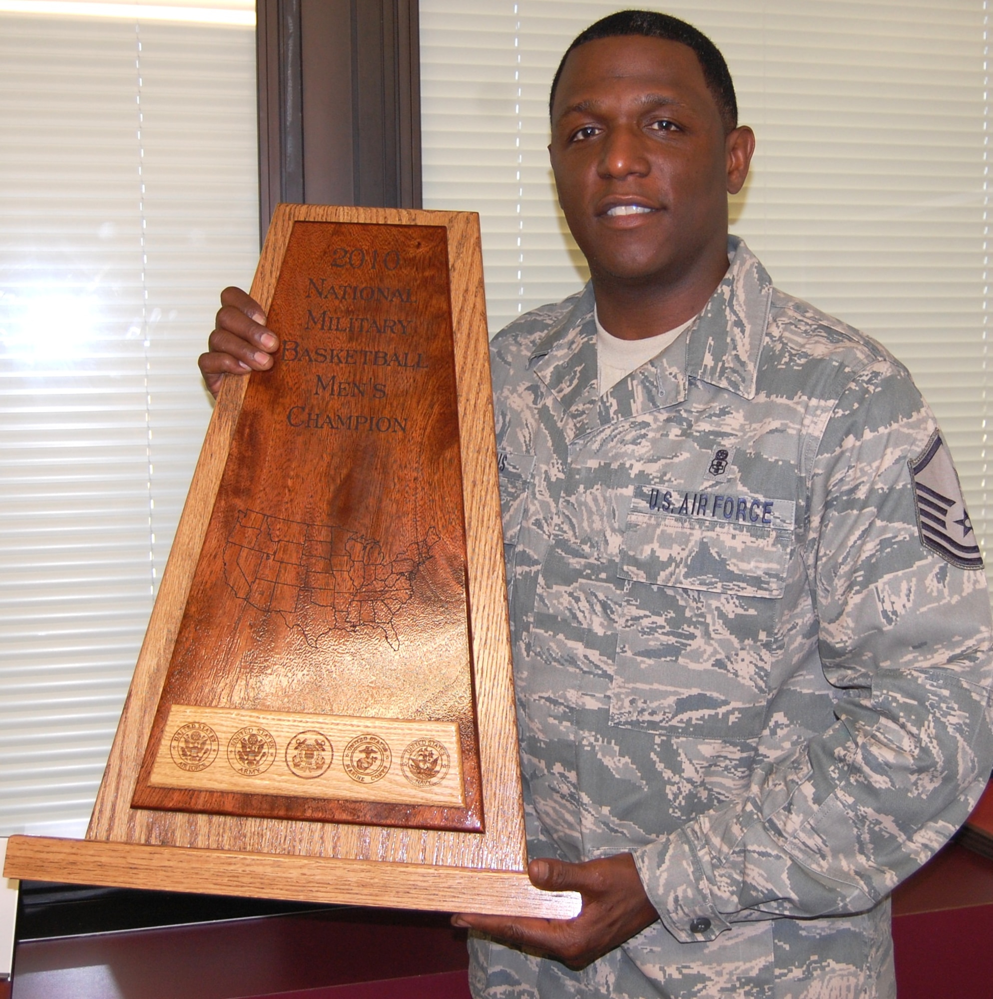 The Keesler Dragons basketball squad is the National Military Athletic Association’s men’s basketball national champion.  Coach Jesse Harris, 81st Inpatient Operations Squadron, displays Keesler’s NMAA trophy.  (U.S. Air Force photo by Steve Pivnick)