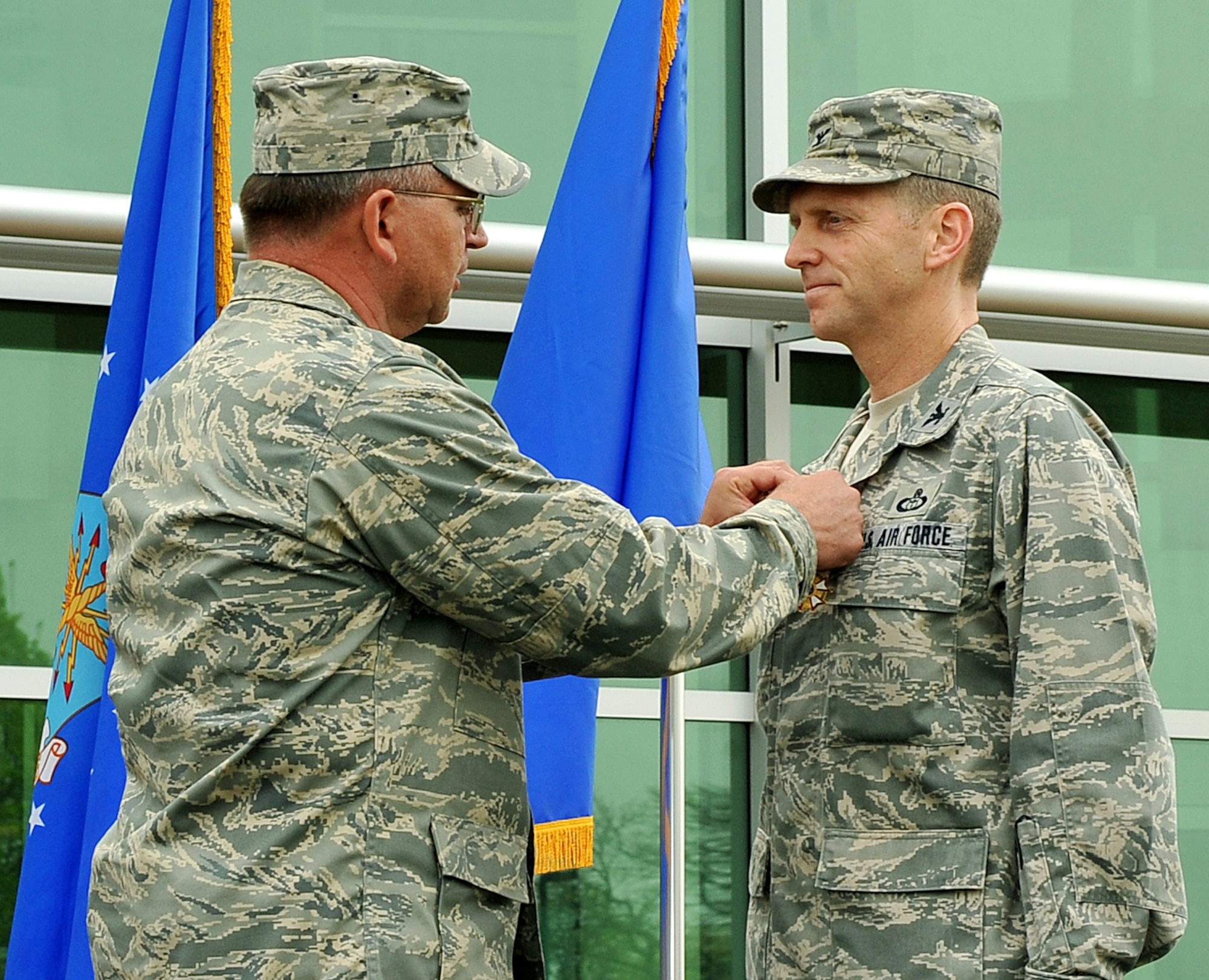 OFFUTT AIR FORCE BASE, Neb. -- Maj. Gen. Marke Gibson, Air Force director of operations and deputy chief of staff for operations, plans and requirements, pins the Legion of Merit medal on Col. John D. Murphy, outgoing Air Force Weather Agency commander, during a change of command ceremony here in front of the Lt. Gen. Thomas S. Moorman building April 20. The agency is comprised of more than 1,400 active-duty members, civil service employees and contractors at 14 operating locations around the world which provide centralized weather products and services, including climatological and space weather support to all branches of the armed forces. U.S. Air Force photo by Charles Haymond
