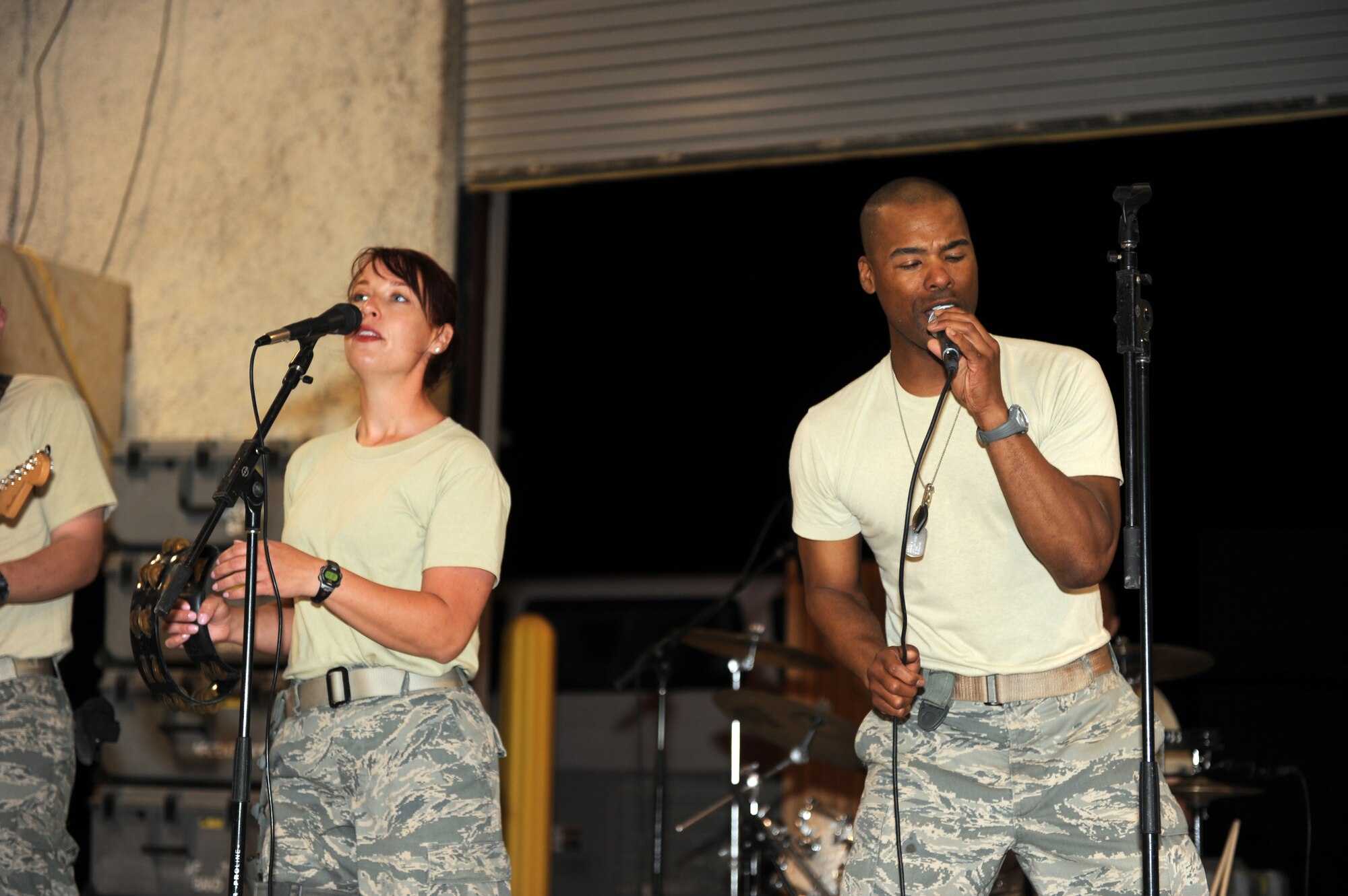 (Left) Airman 1st Class Jill Diem, vocalist, and Master Sgt. Aaron Miles, non-commissioned officer in charge of U.S. Air Forces Central Band Reserve Generation, perform a duet during a concert at Bagram Airfield, Afghanistan, April 17, 2010. The band is completing a two-month tour of Southwest Asia and is deployed from Robins Air Force Base, Ga.  (U.S. Air Force photo by/ Staff Sgt. Richard Williams)
